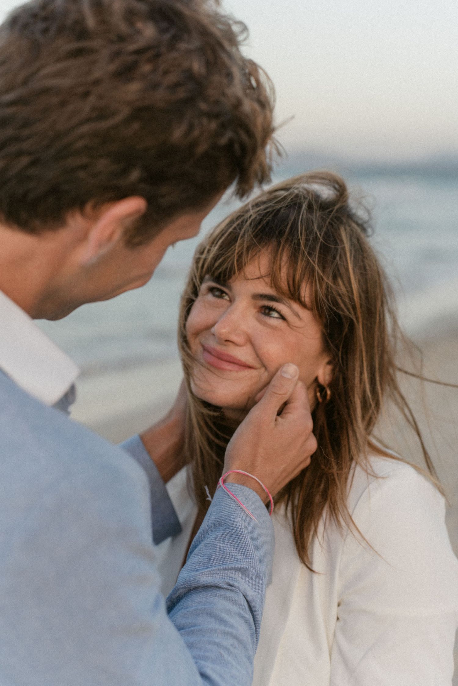 Intimate beach portrait series showing gentle affection between couple.