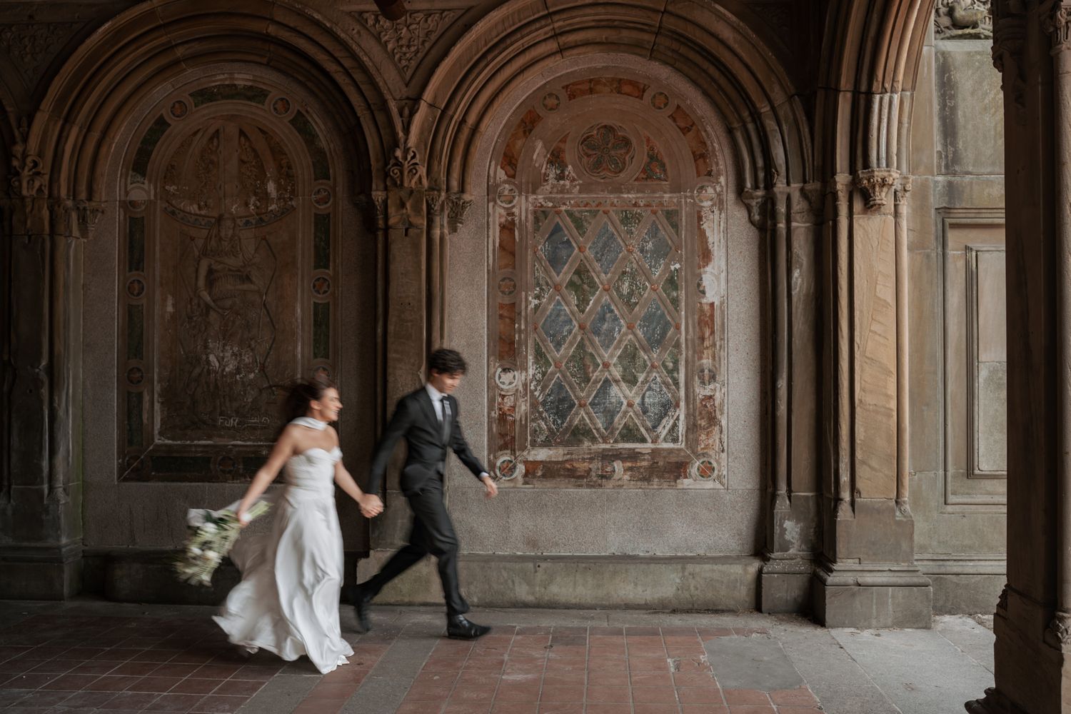 Romantic couple dancing in an ornate architectural setting with frescoed walls.