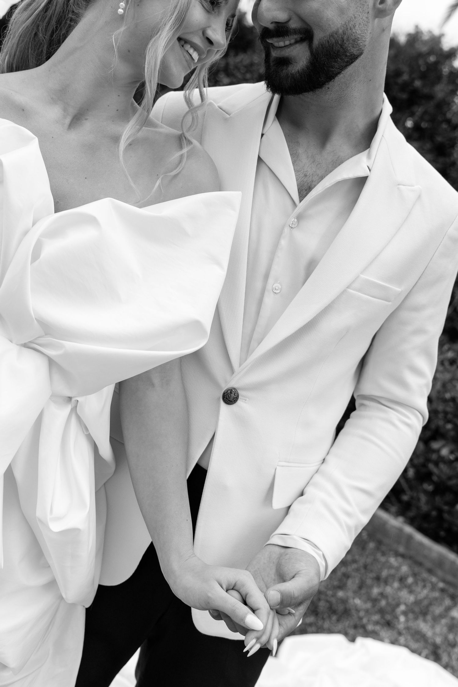 Black and white close-up photos of elegant white wedding attire details.