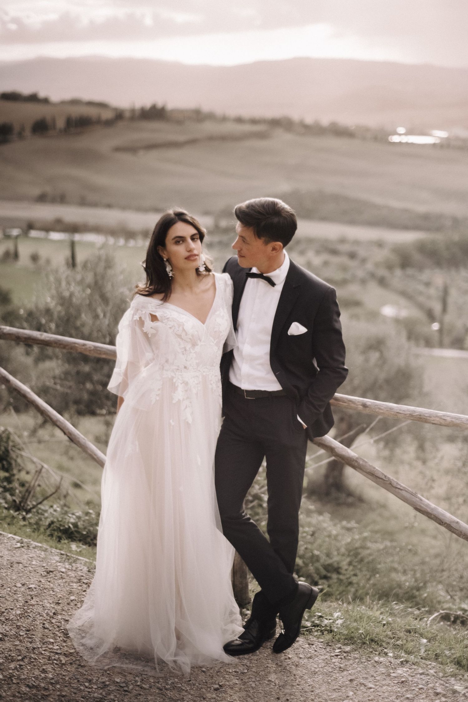 A romantic countryside wedding photoshoot with rolling hills in the background.