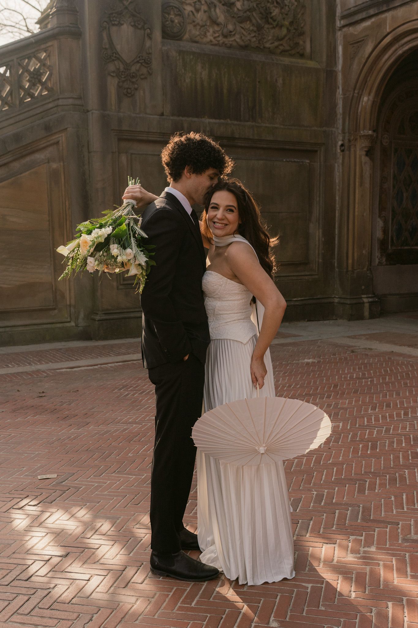 Wedding couple shares joyful dance moves on herringbone brick terrace.