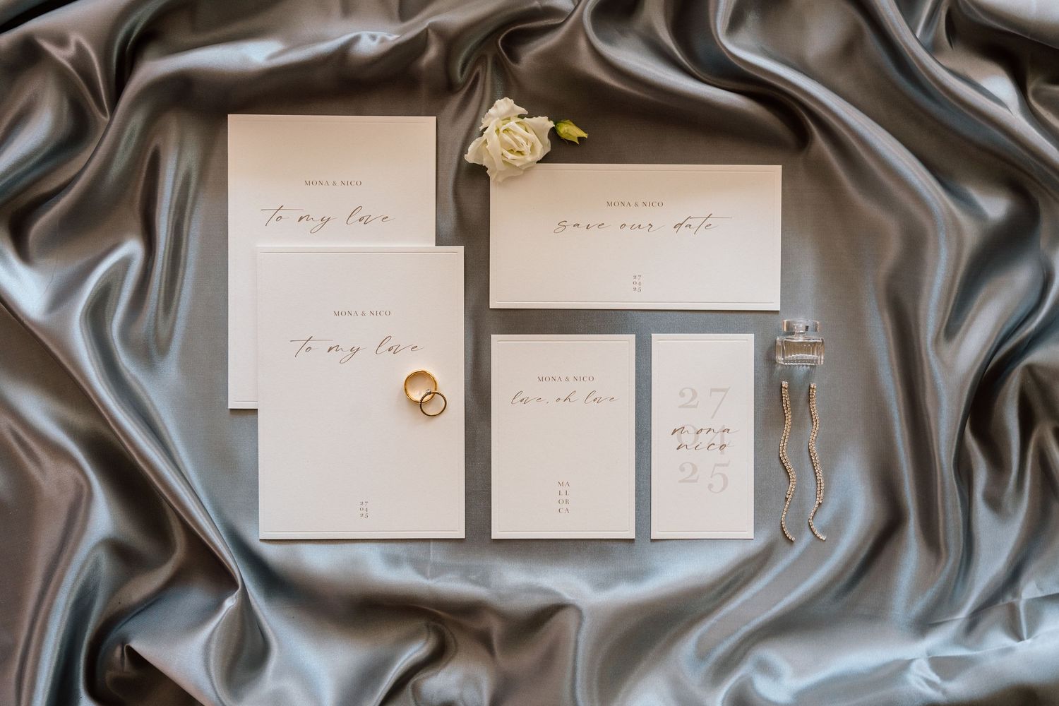 Wedding stationery laid out on dark silk fabric with elegant styling.
