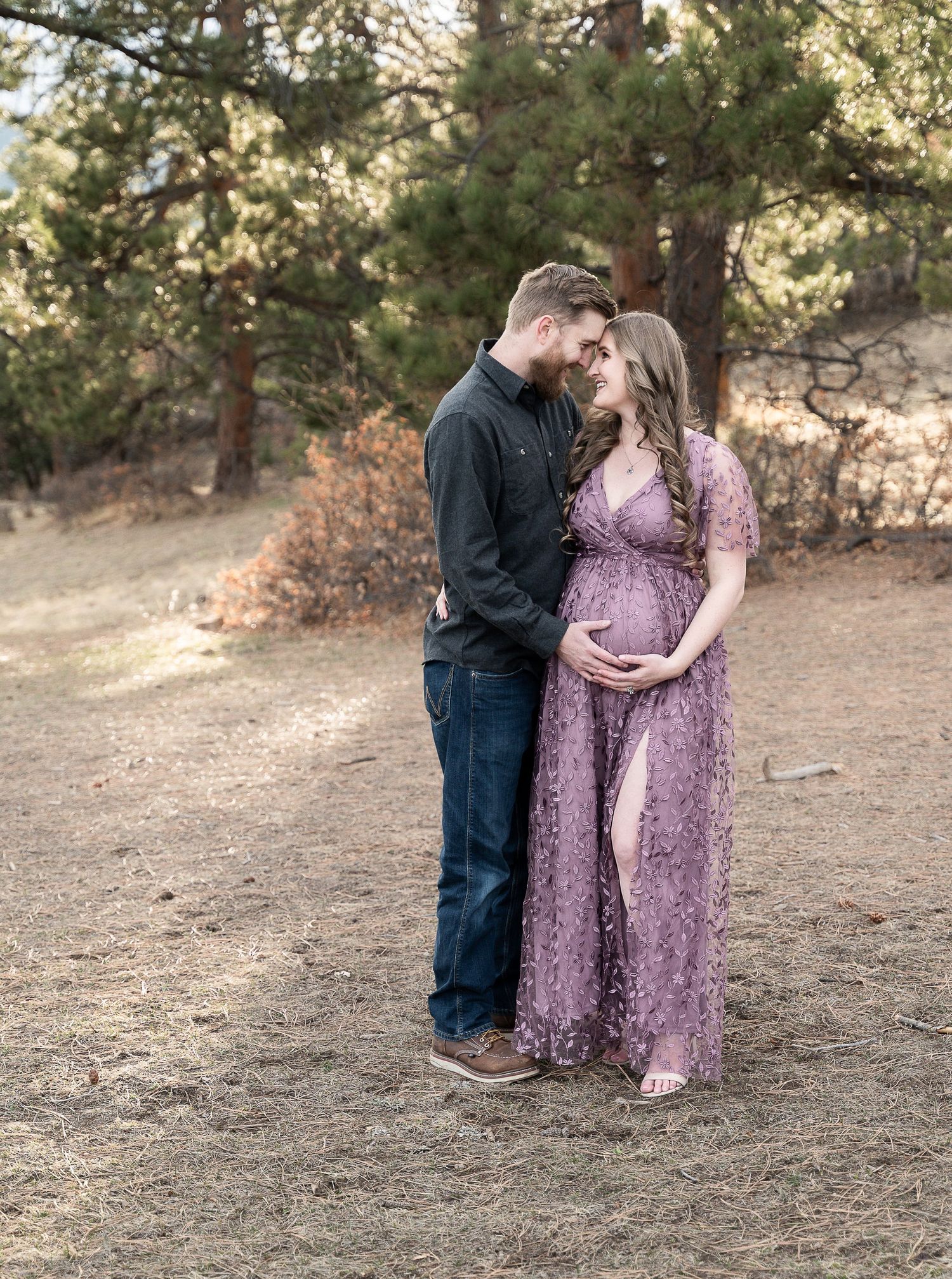A tender moment captured between a couple during their maternity photoshoot in nature.