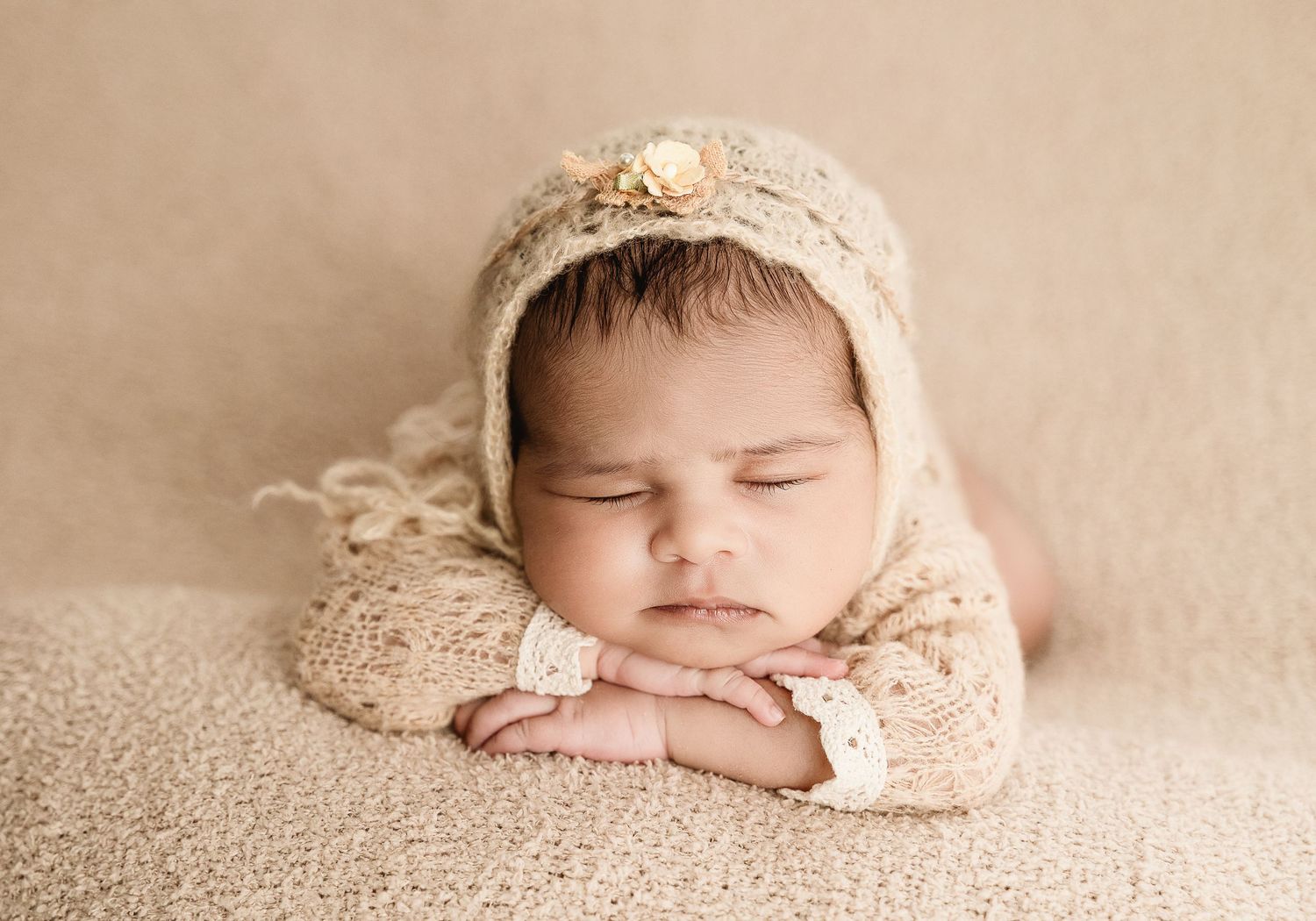 Series of five artistic newborn portraits in soft beige tones showing delicate sleeping positions.