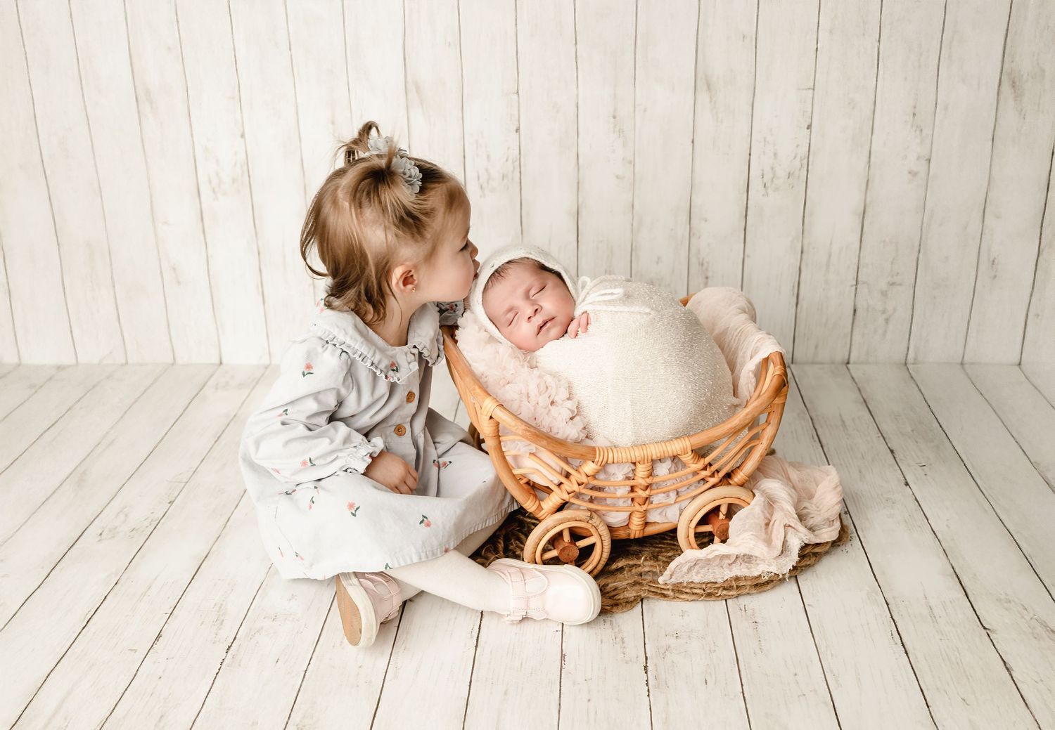 A series of four connected images showing a baby in white clothing lying on wooden floor panels.