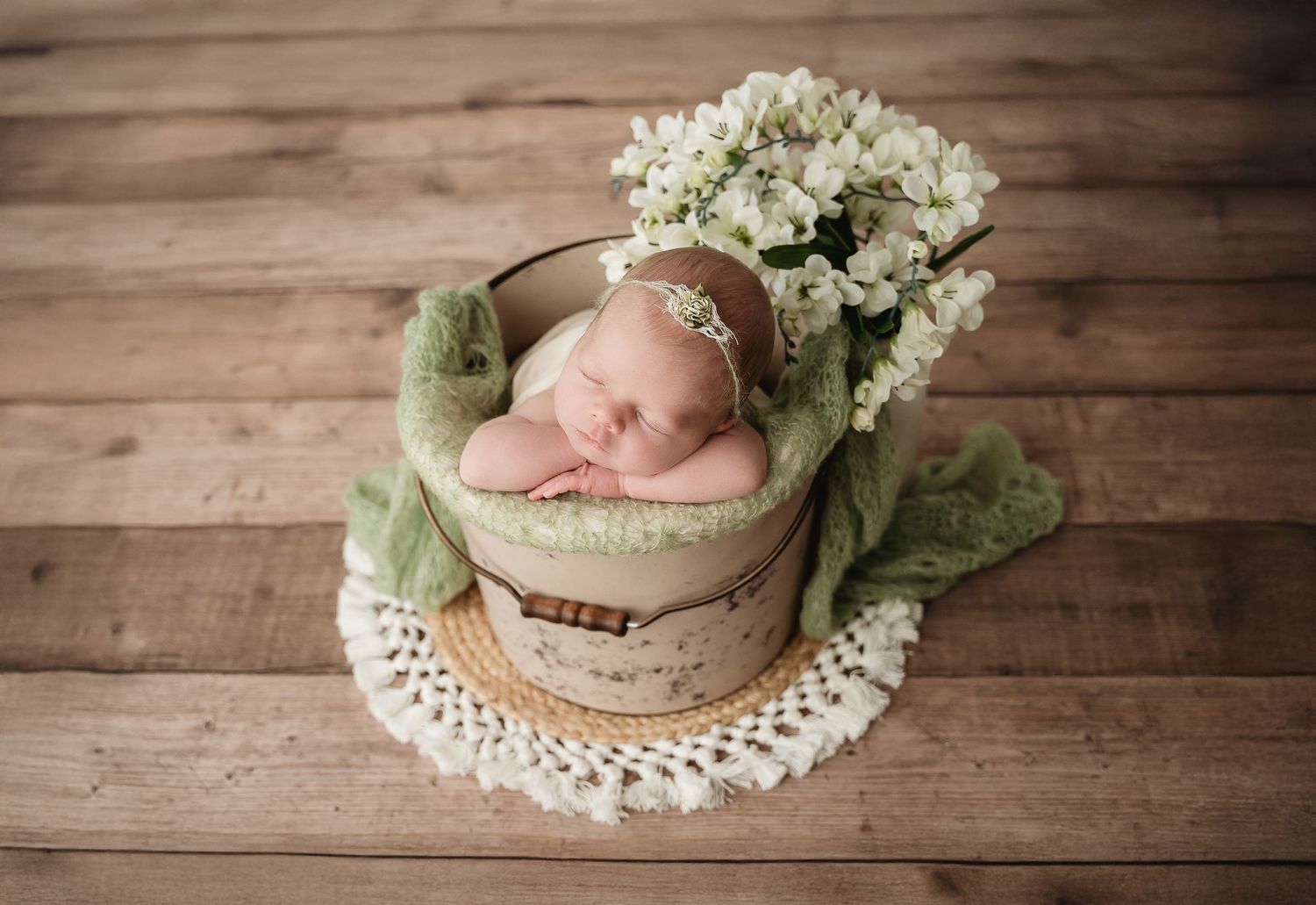 Newborn baby photography series with white flowers and vintage wooden backdrop styling.