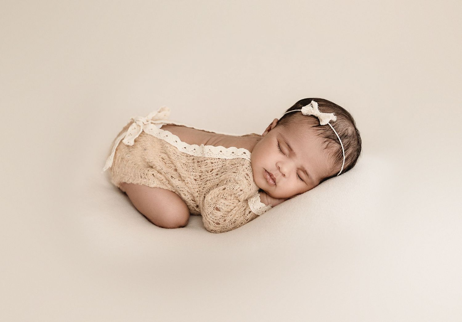 Series of four peaceful newborn baby photos showing gentle sleeping poses on cream colored backdrop.