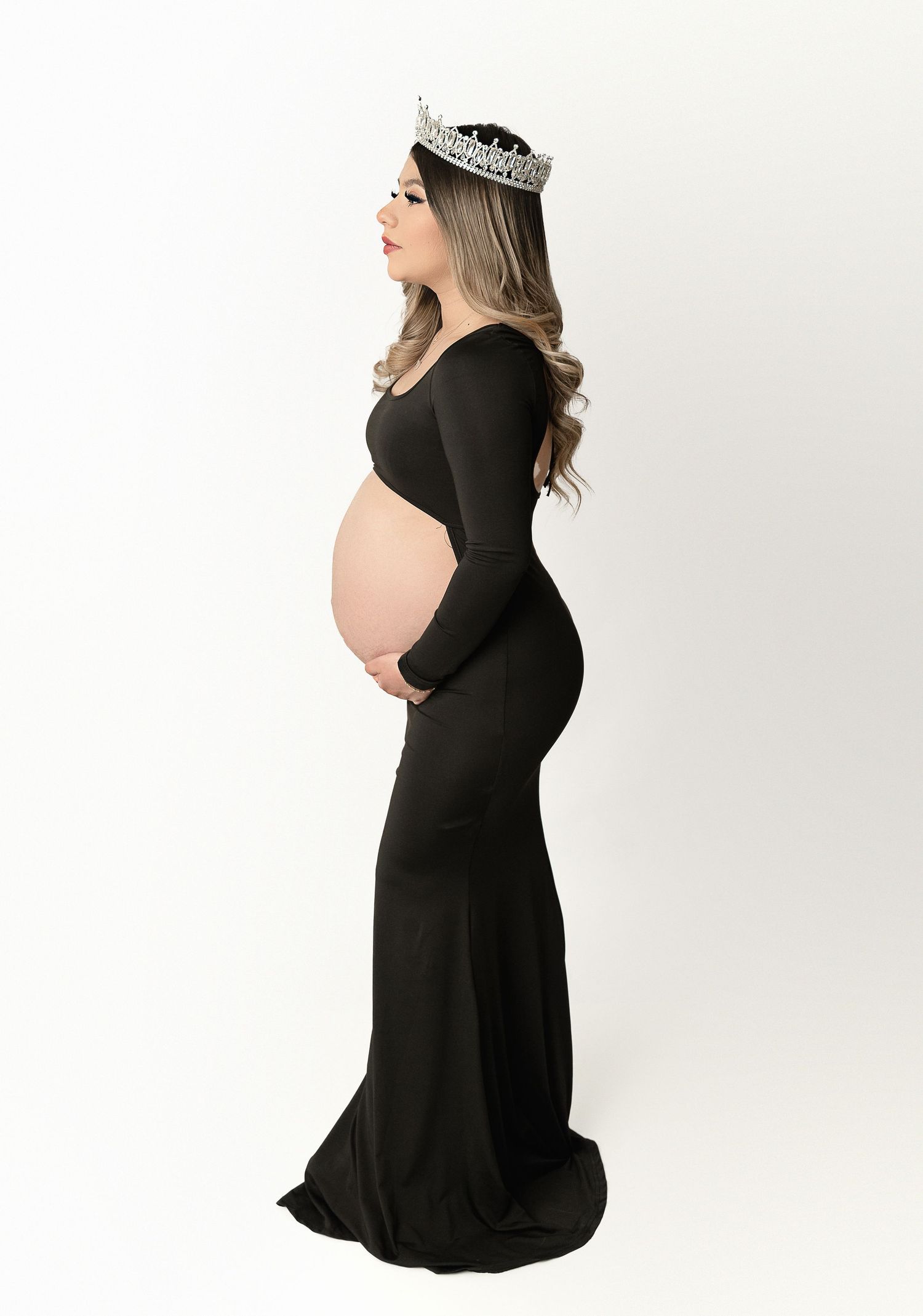 A maternity portrait shows an expectant mother in a black dress and crown against white background.