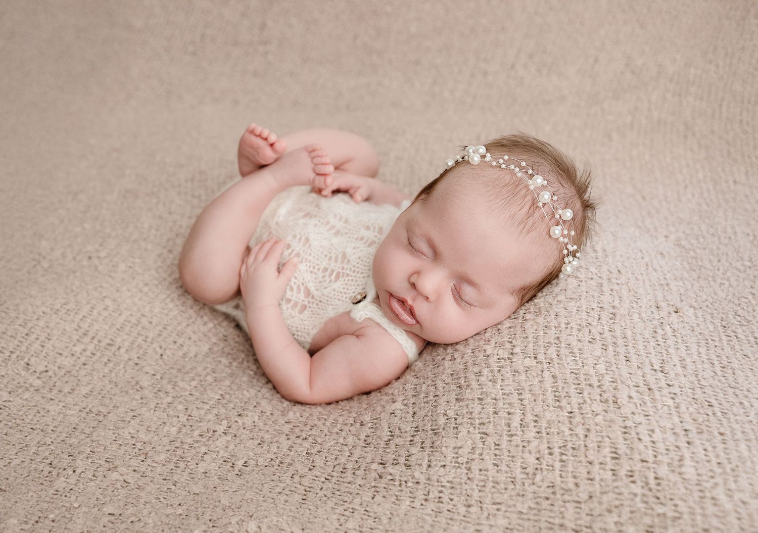 A set of peaceful newborn baby photos on beige fabric showing various sleeping poses and delicate bow accessories.