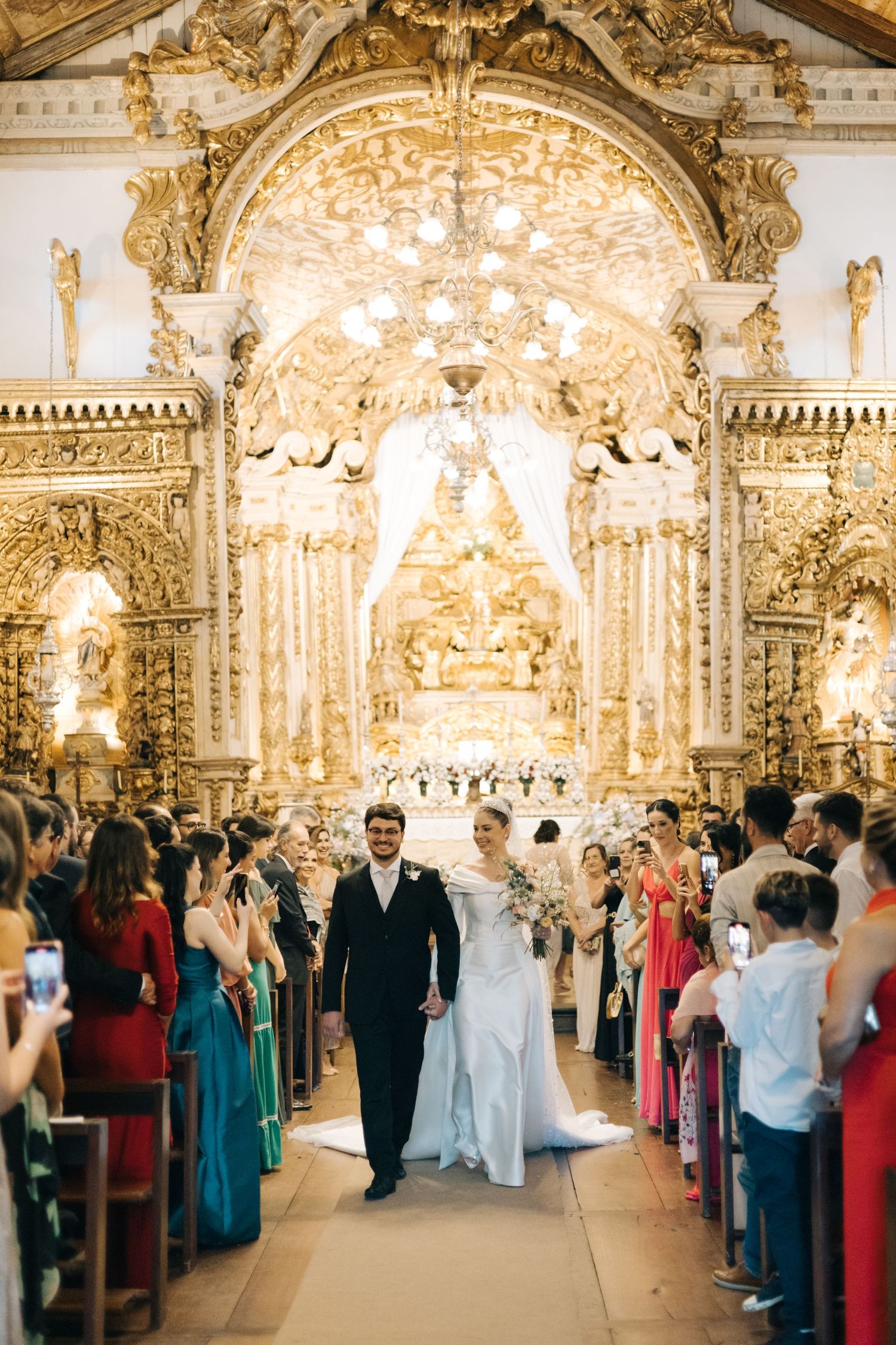 Ornate golden altar and decorative church interior during wedding ceremony.