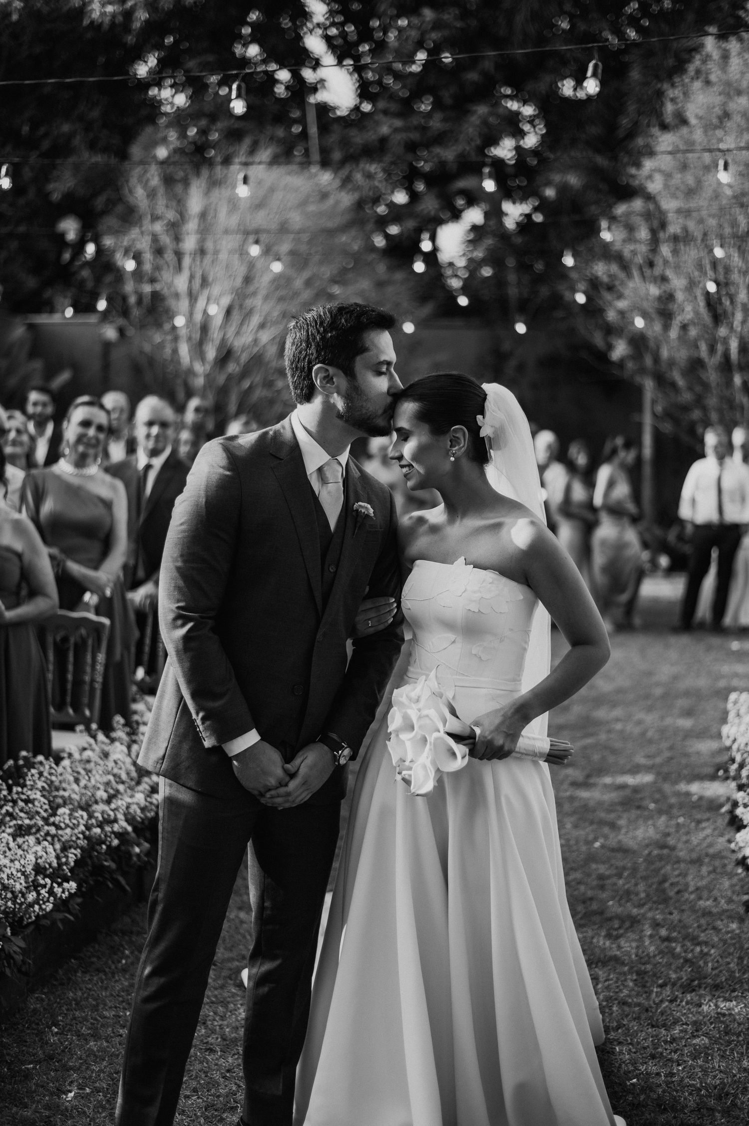 Intimate garden wedding ceremony with elegant couple and gathered guests.