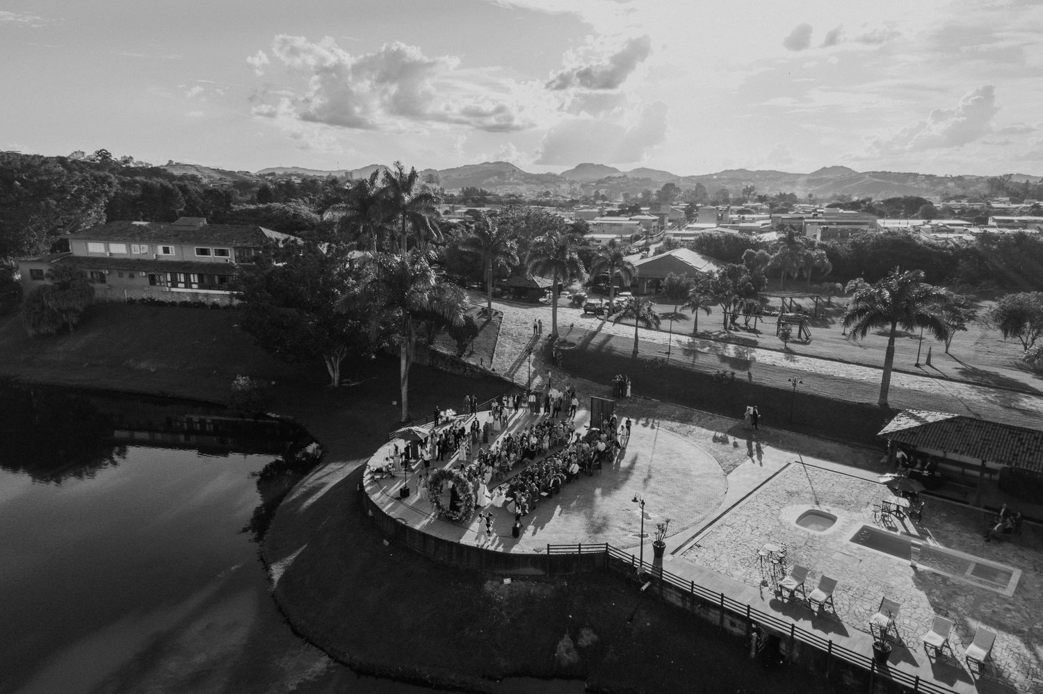 Aerial black and white view of tropical venue with palm trees and water features.