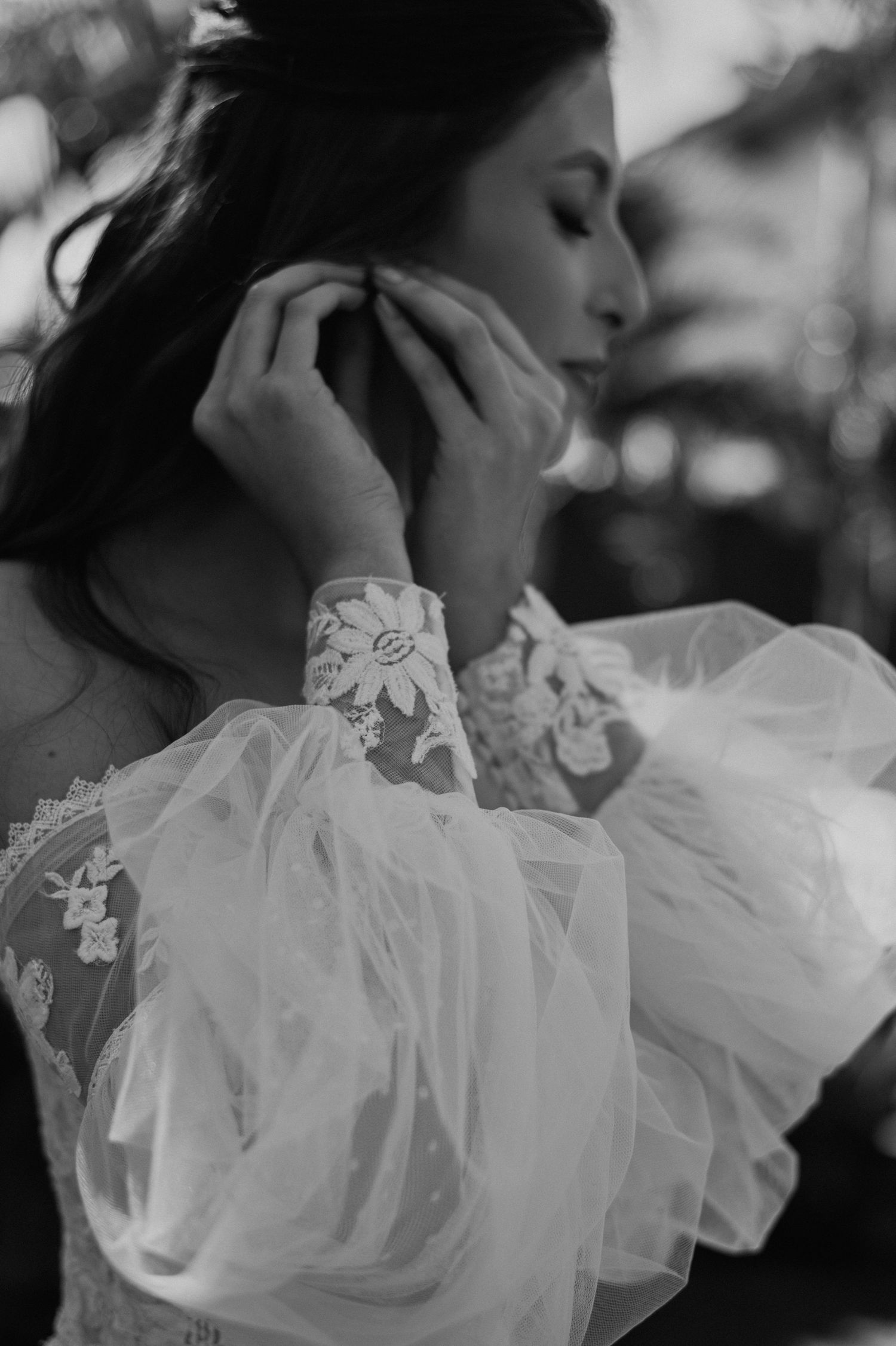 Close-up of delicate lace and tulle wedding dress sleeve details in black and white.