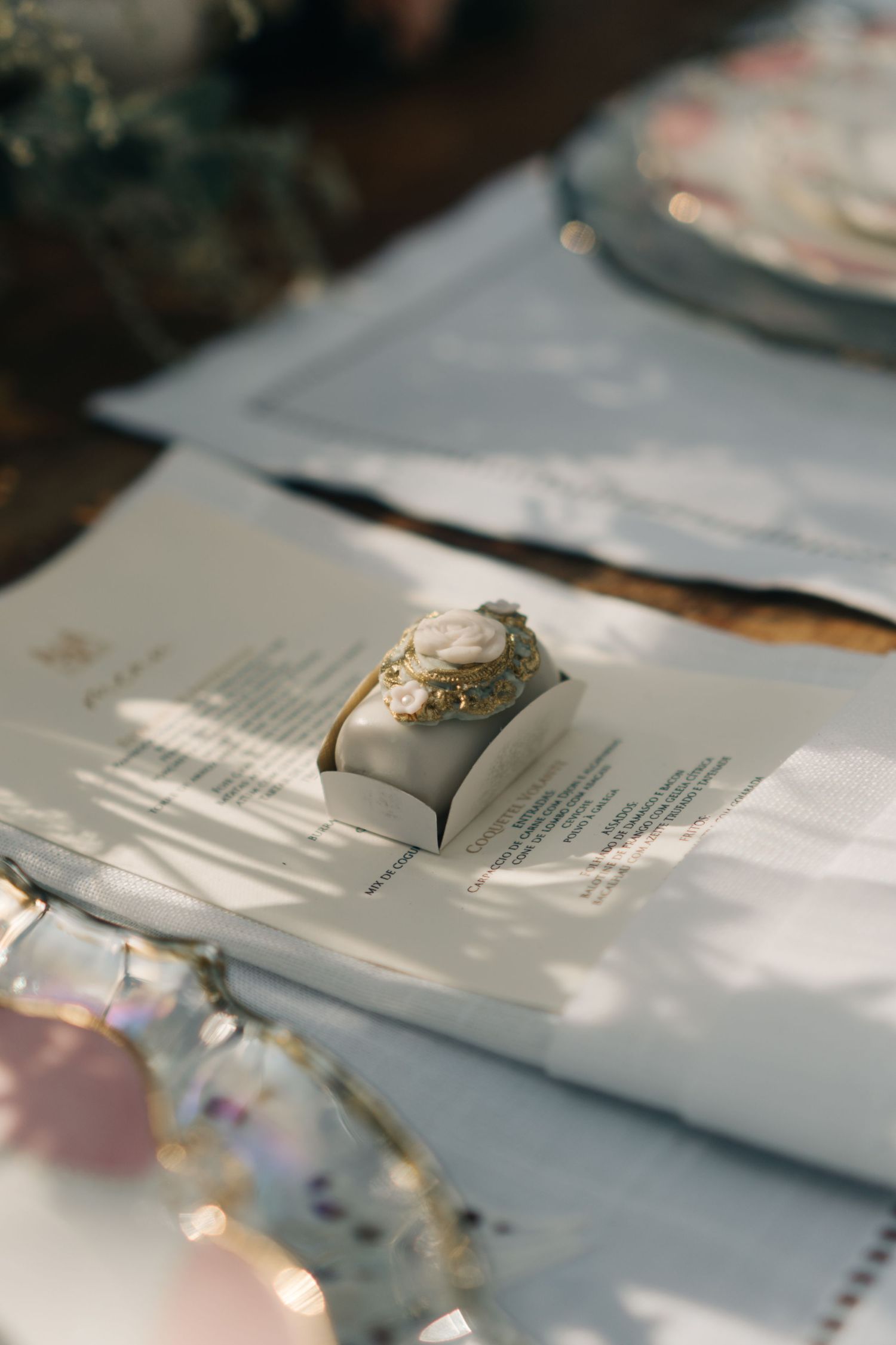 Close-up of a wedding ring resting on white paper menu in natural daylight.