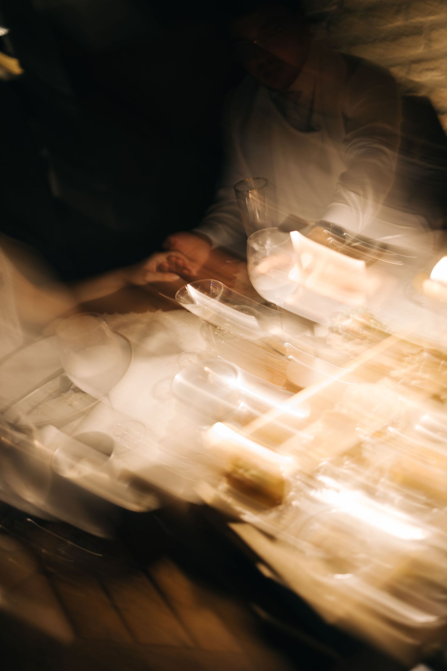 Abstract motion blur of wedding reception table settings with warm lighting.