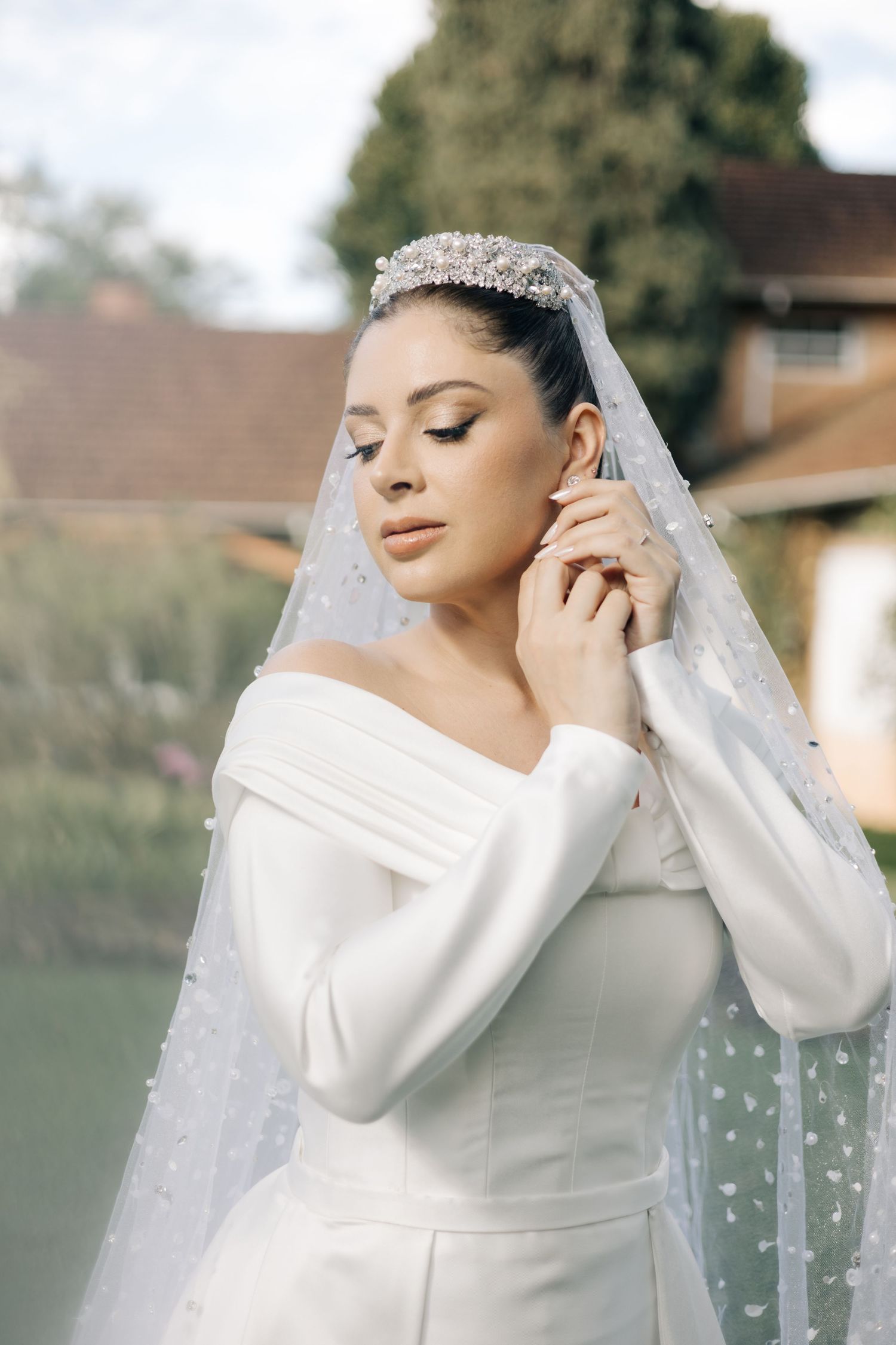 Elegant bridal portrait featuring an off-shoulder wedding gown and crystal-embellished veil.