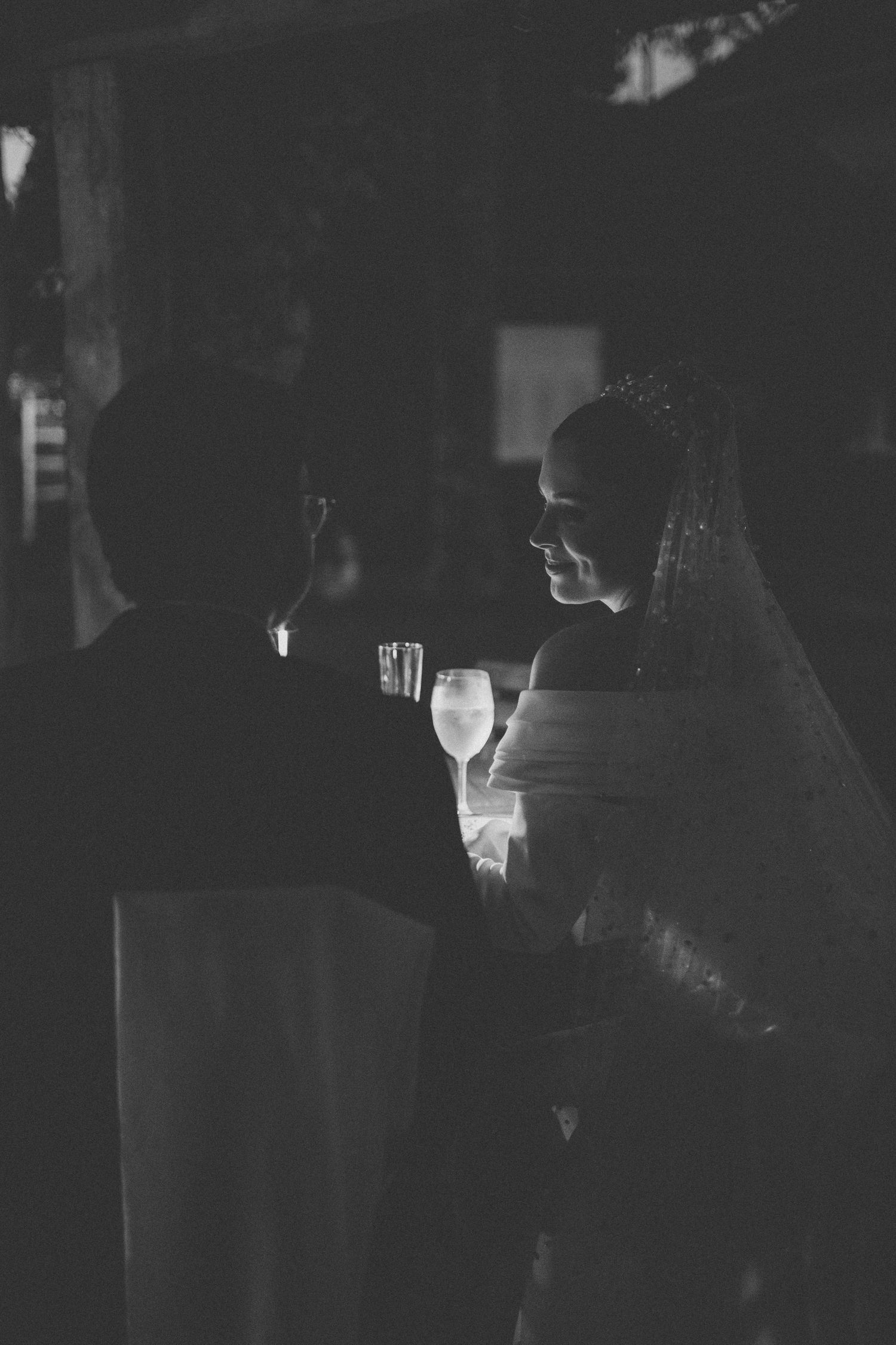 Silhouette of a couple sharing drinks in dramatic black and white lighting.