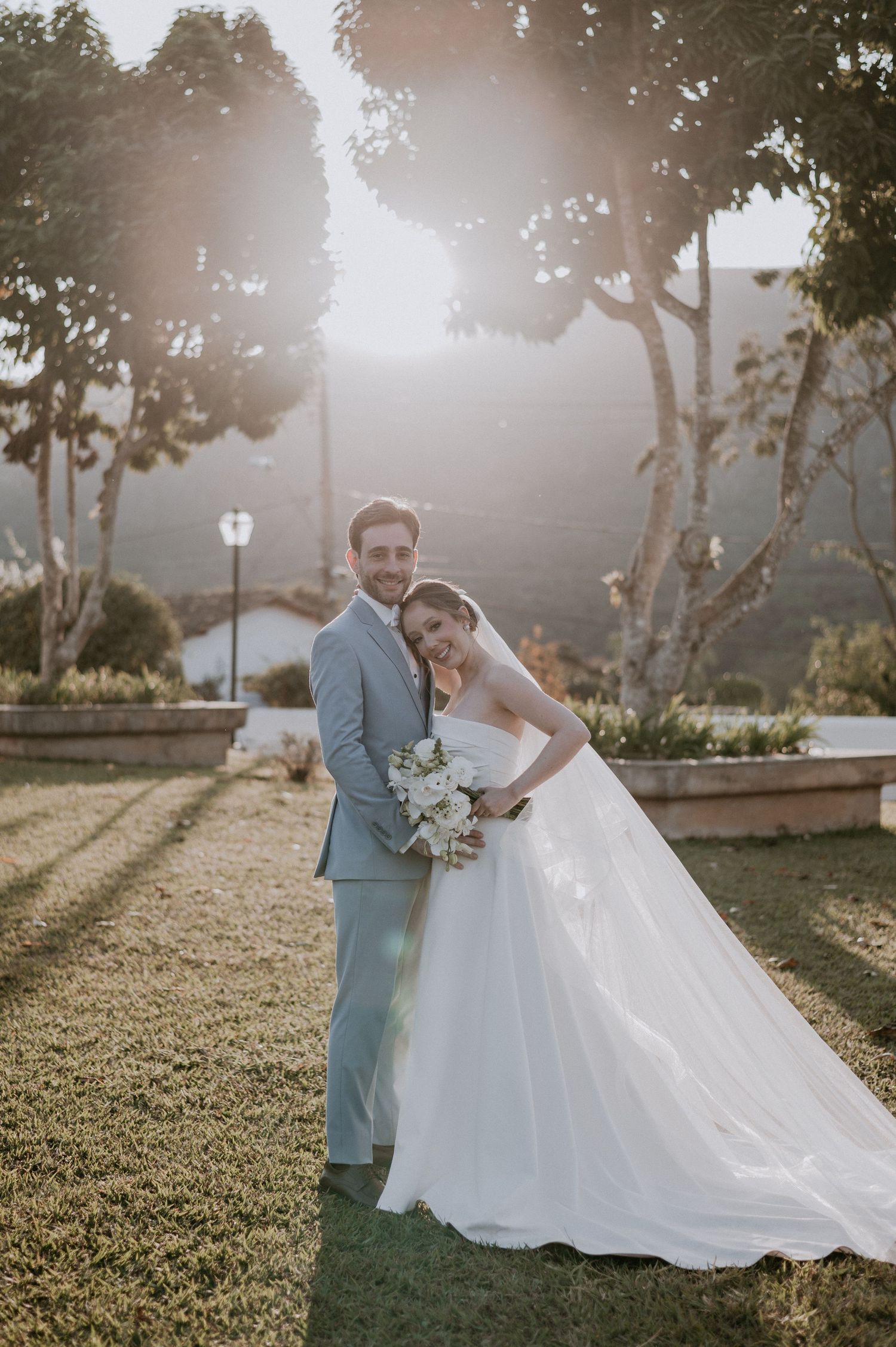 Sunset wedding portrait with mountain backdrop and elegant garden setting.