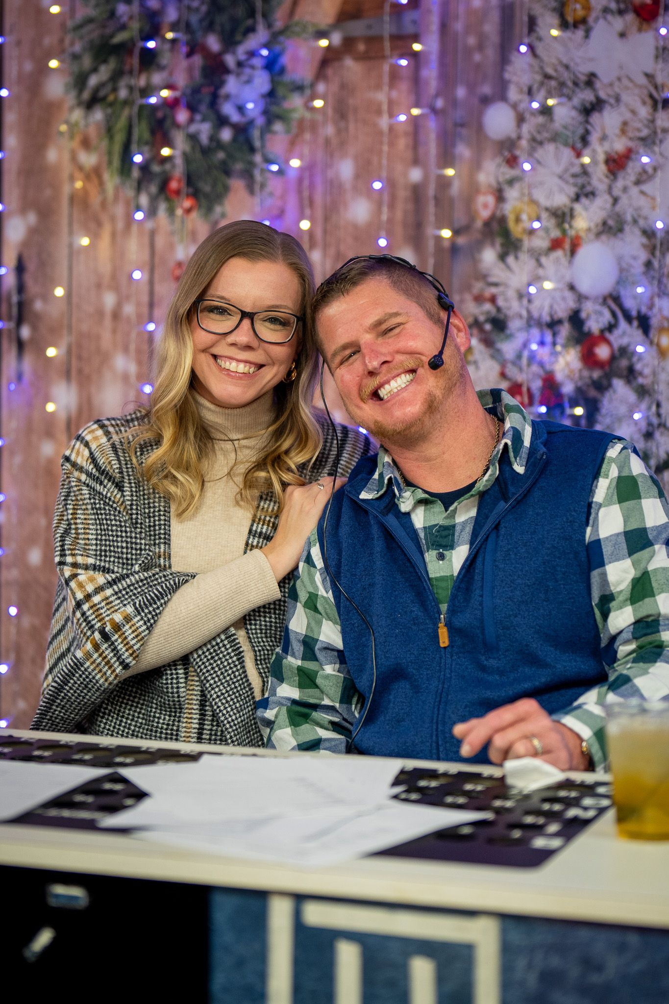 Two people in casual winter attire share a joyful moment at festive gathering.