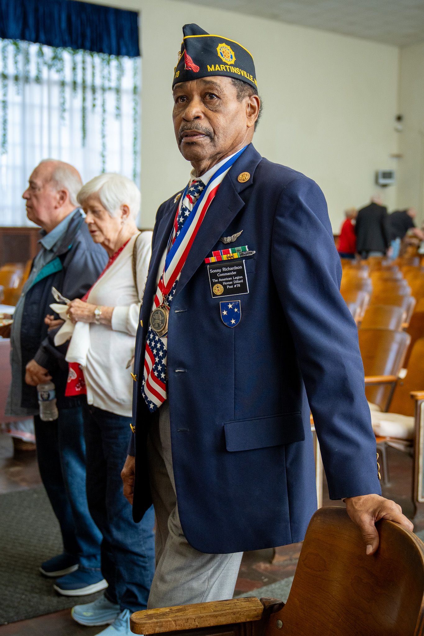 Military veterans in American Legion uniforms gather together at a community event.