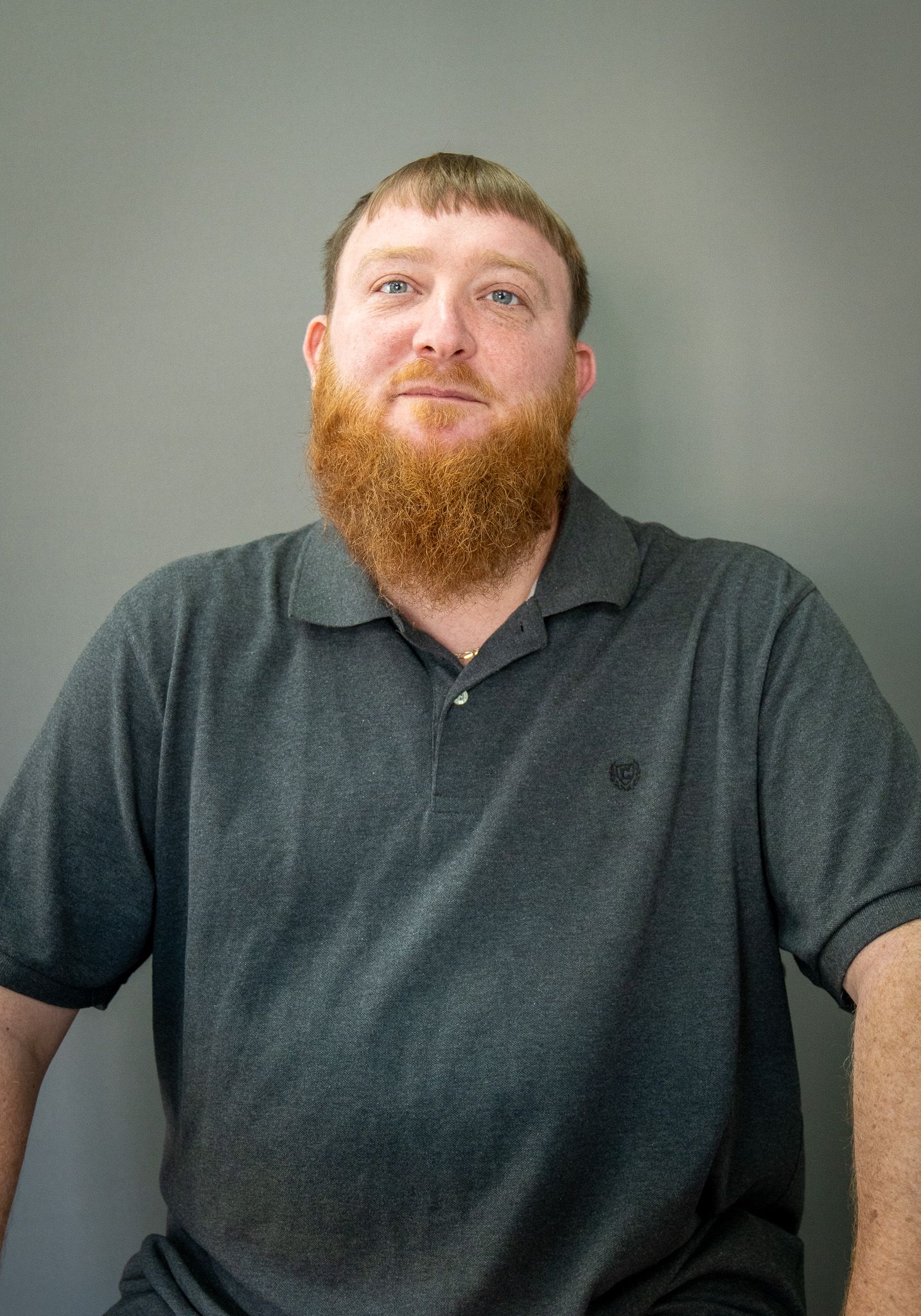 A series of five images showing someone in a gray polo shirt posing against a plain gray wall.