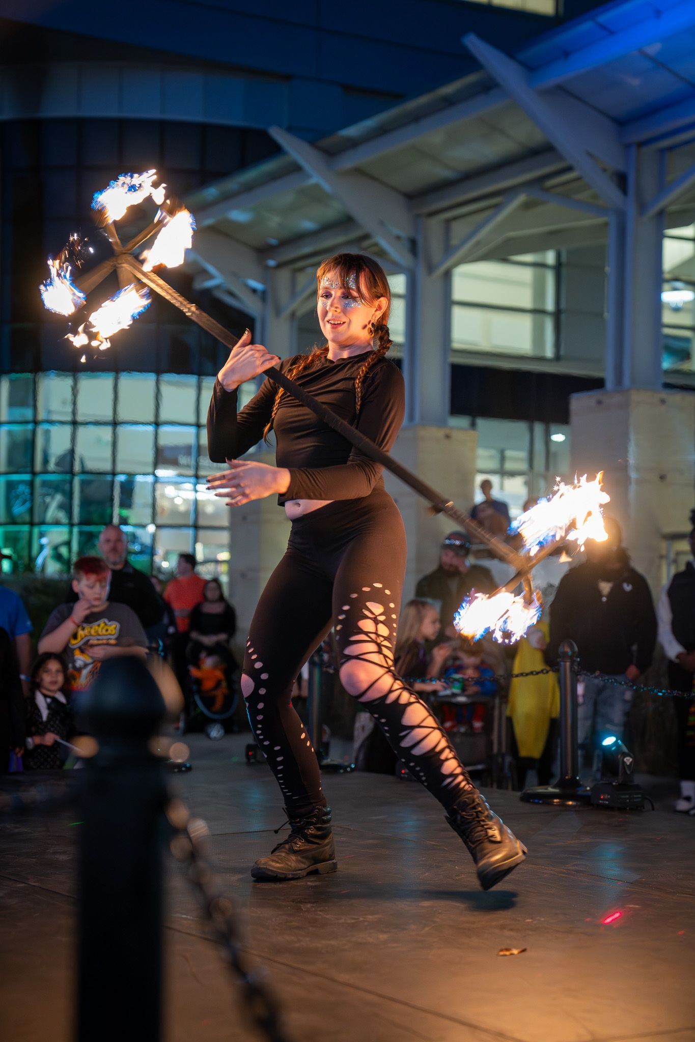 A performer twirls flaming torches in a dramatic fire dance sequence captured in multiple action shots across 5 frames.