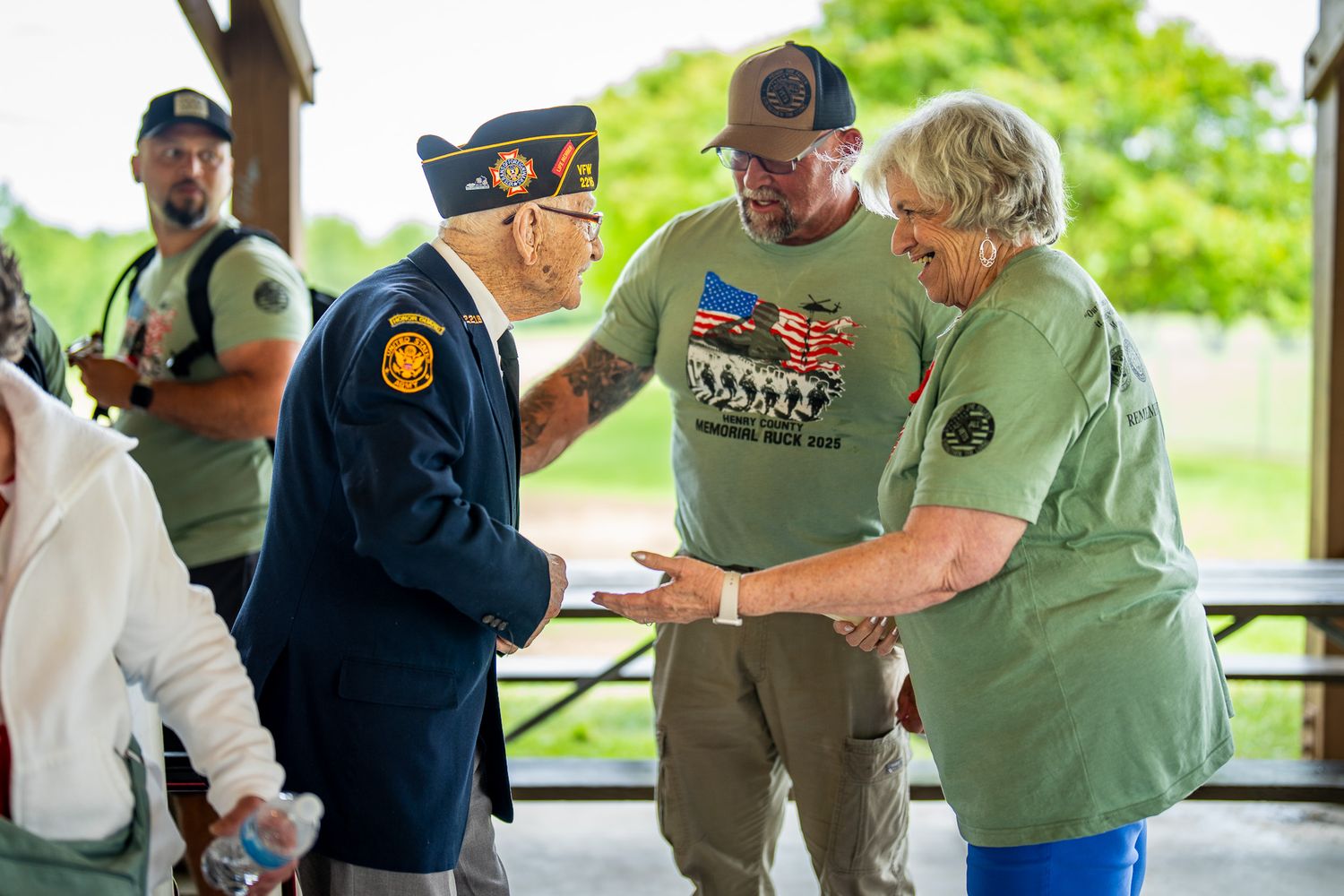 Veterans sharing a moment at military appreciation event under outdoor pavilion.