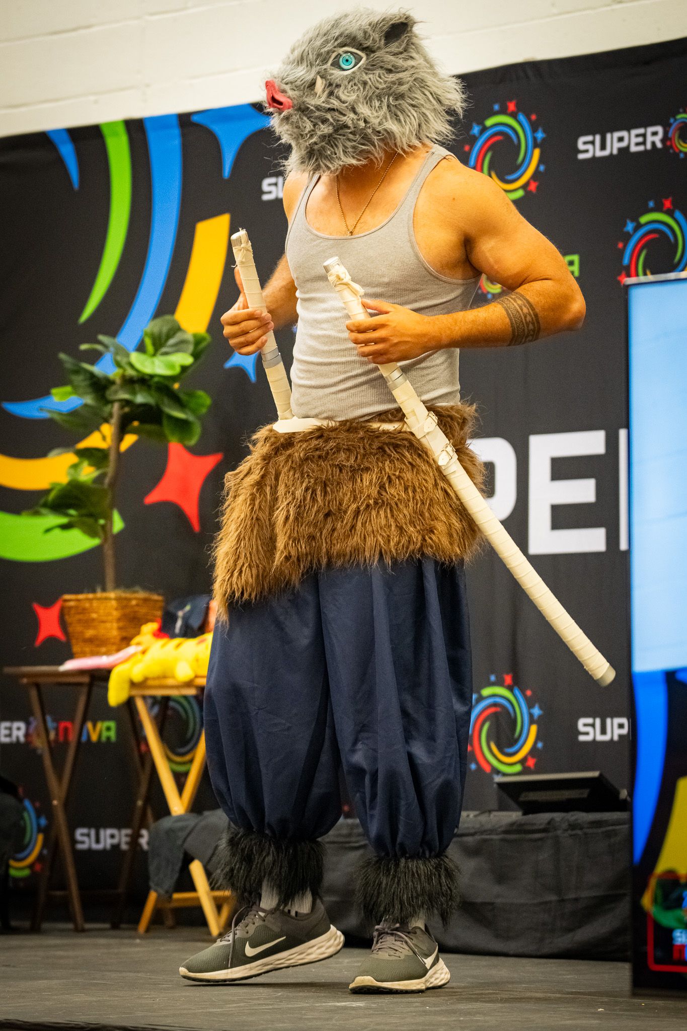Close-up sequence of someone in navy pants swinging a toy lightsaber in front of a colorful backdrop with star decorations.