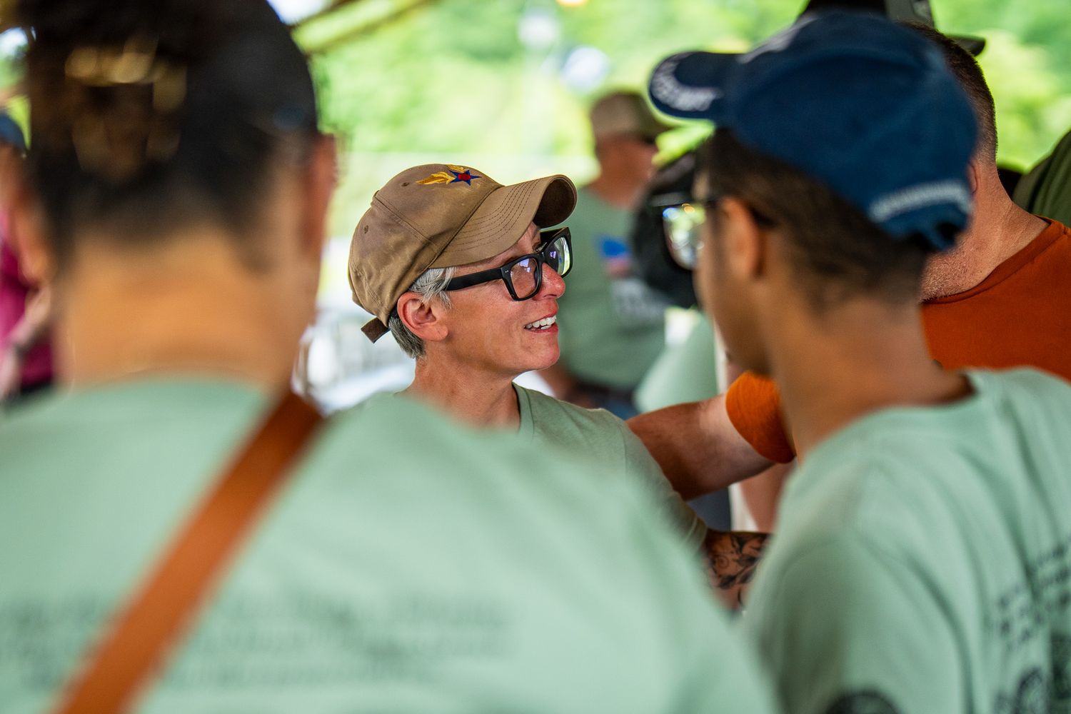Participants gather and socialize during an outdoor veterans event on a sunny day.