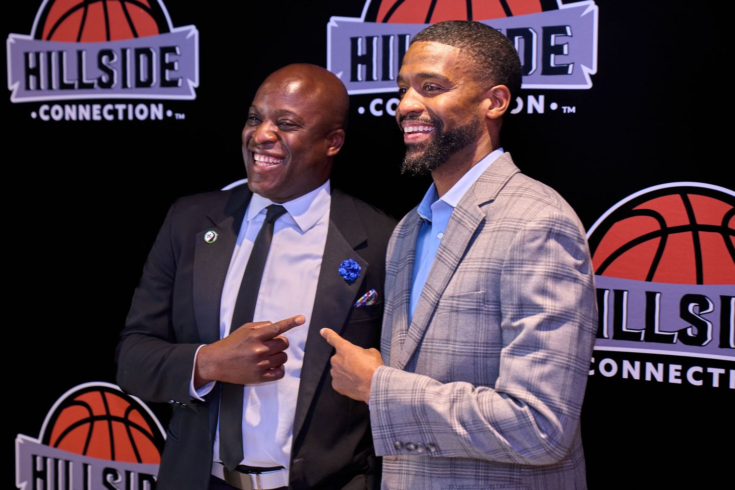 Two speakers at basketball event with Hillside Connection branding in background.