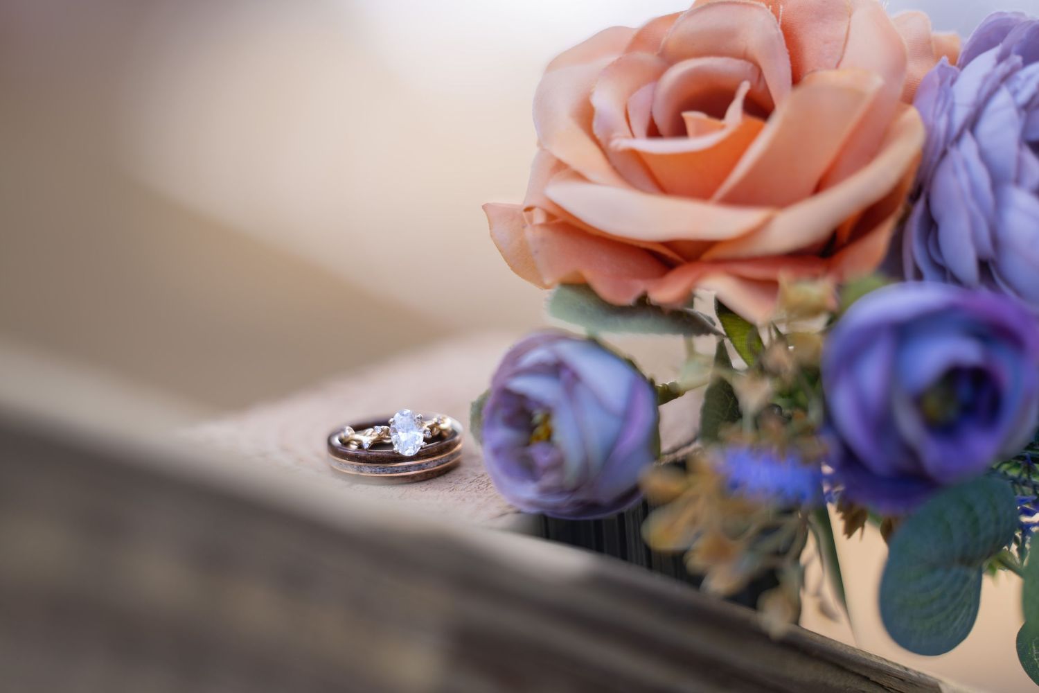 Delicate pink roses and purple flowers arranged as wedding decorations.