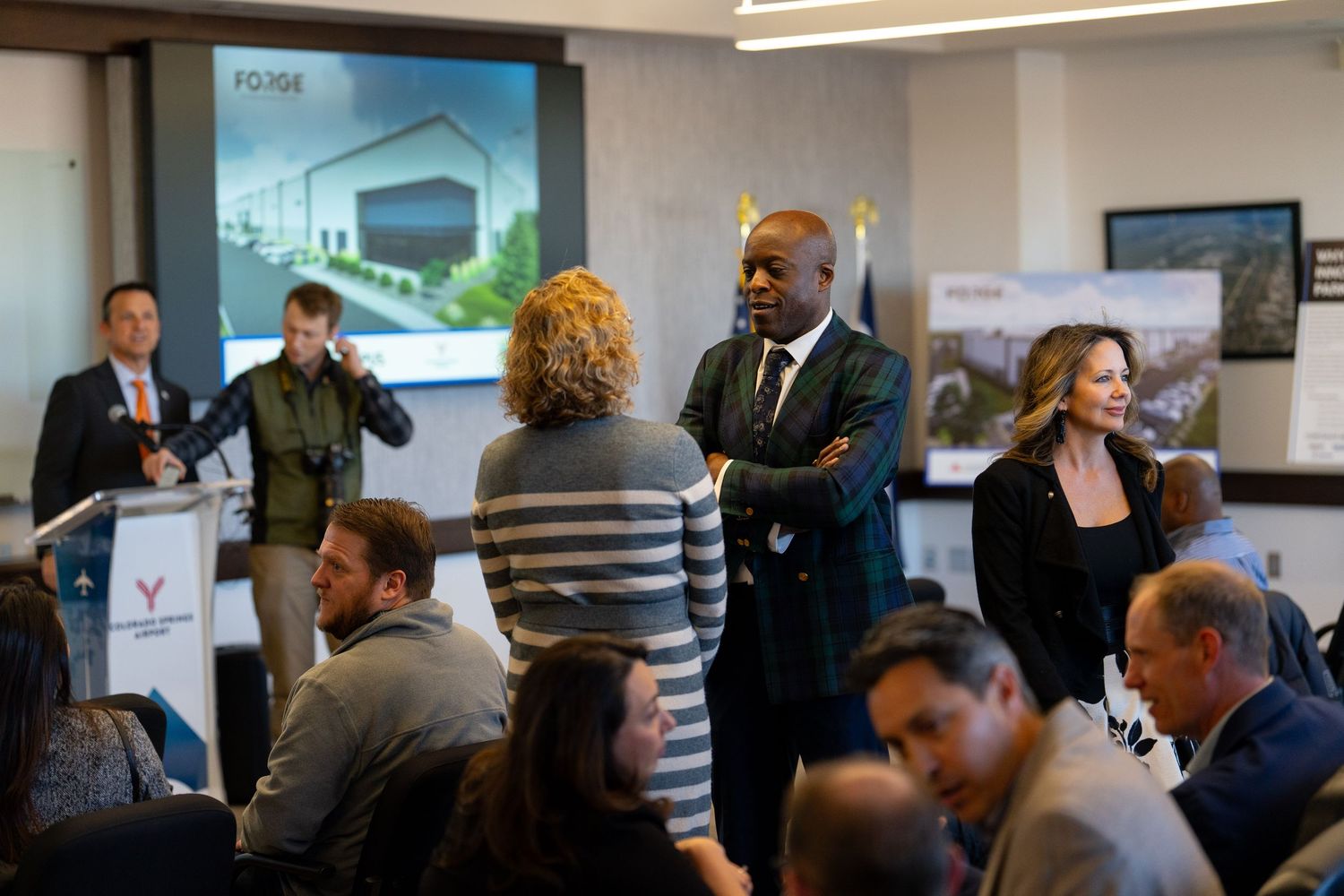 Business professionals gathered for a formal presentation in a modern conference room.