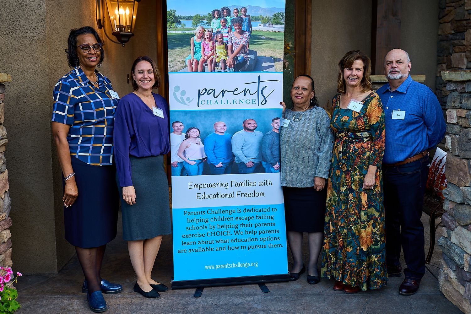 Group of people standing with a organizational banner for a parents program event.
