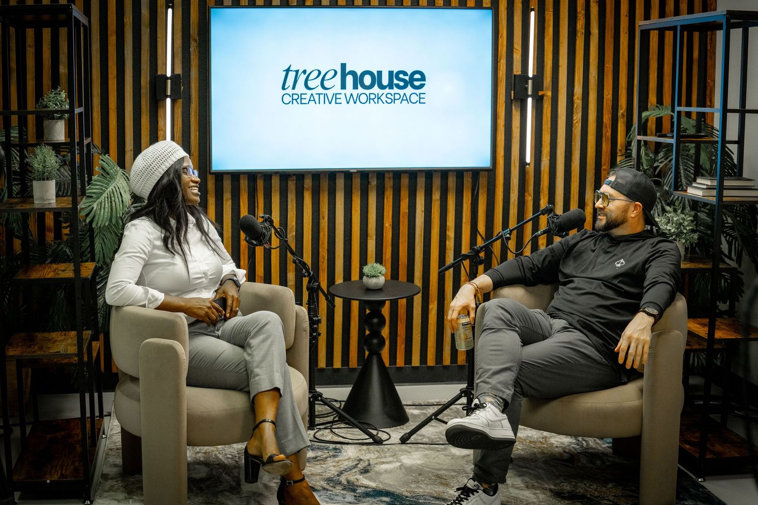 Two people having a conversation at Treehouse Creative Workspace, seated in modern chairs against a stylish studio backdrop.
