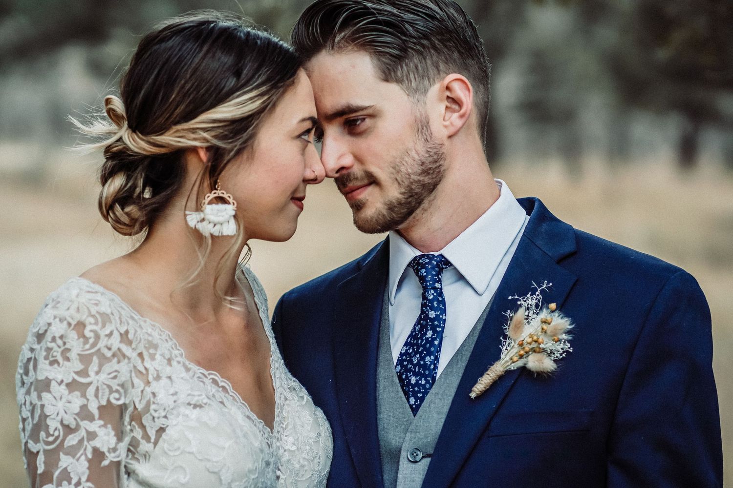 Close-up of intimate wedding couple moment with groom in navy suit.