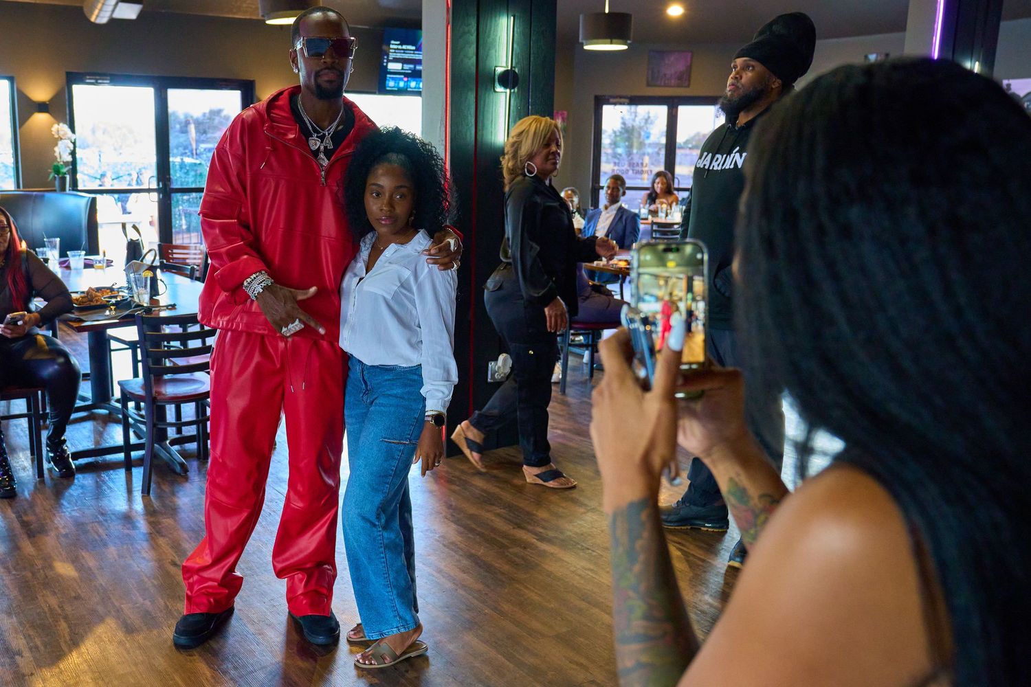 Photographer capturing a moment at a social gathering in an indoor venue.