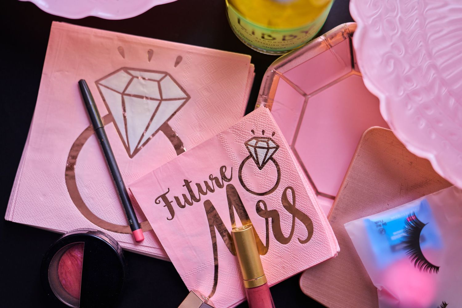 Pink wedding planning notecards with diamond ring illustrations and gold accents on a dark surface.
