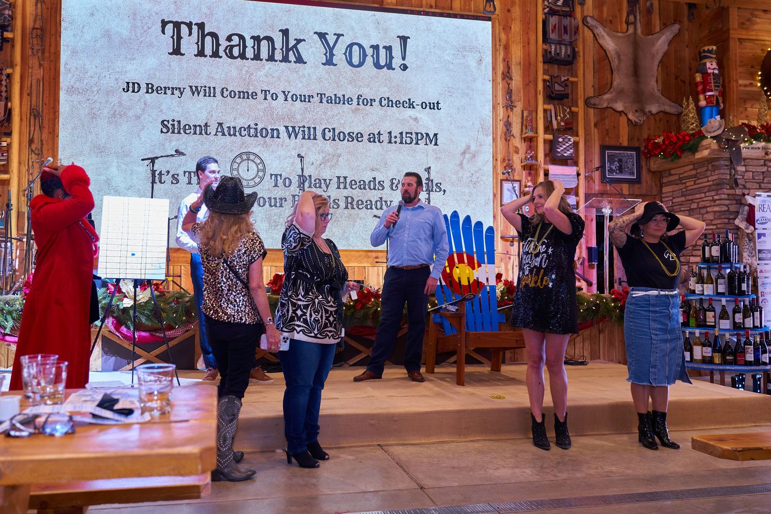 People standing in front of a 'Thank You' banner during an event celebration.