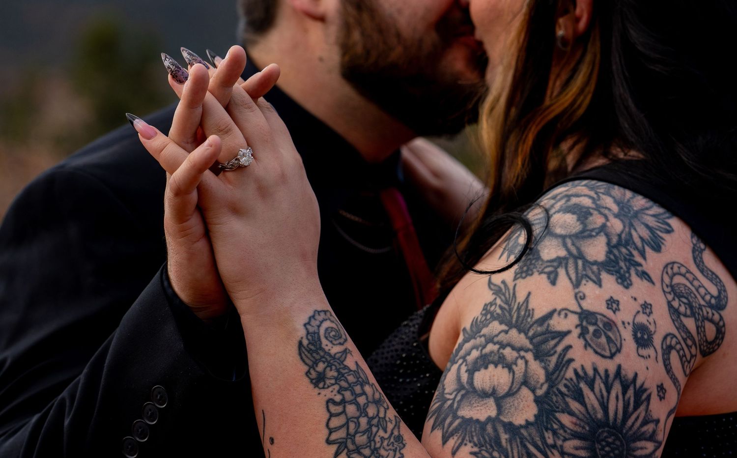 A series of black and white close-up shots showing detailed arm tattoos and hand gestures against dark backgrounds.