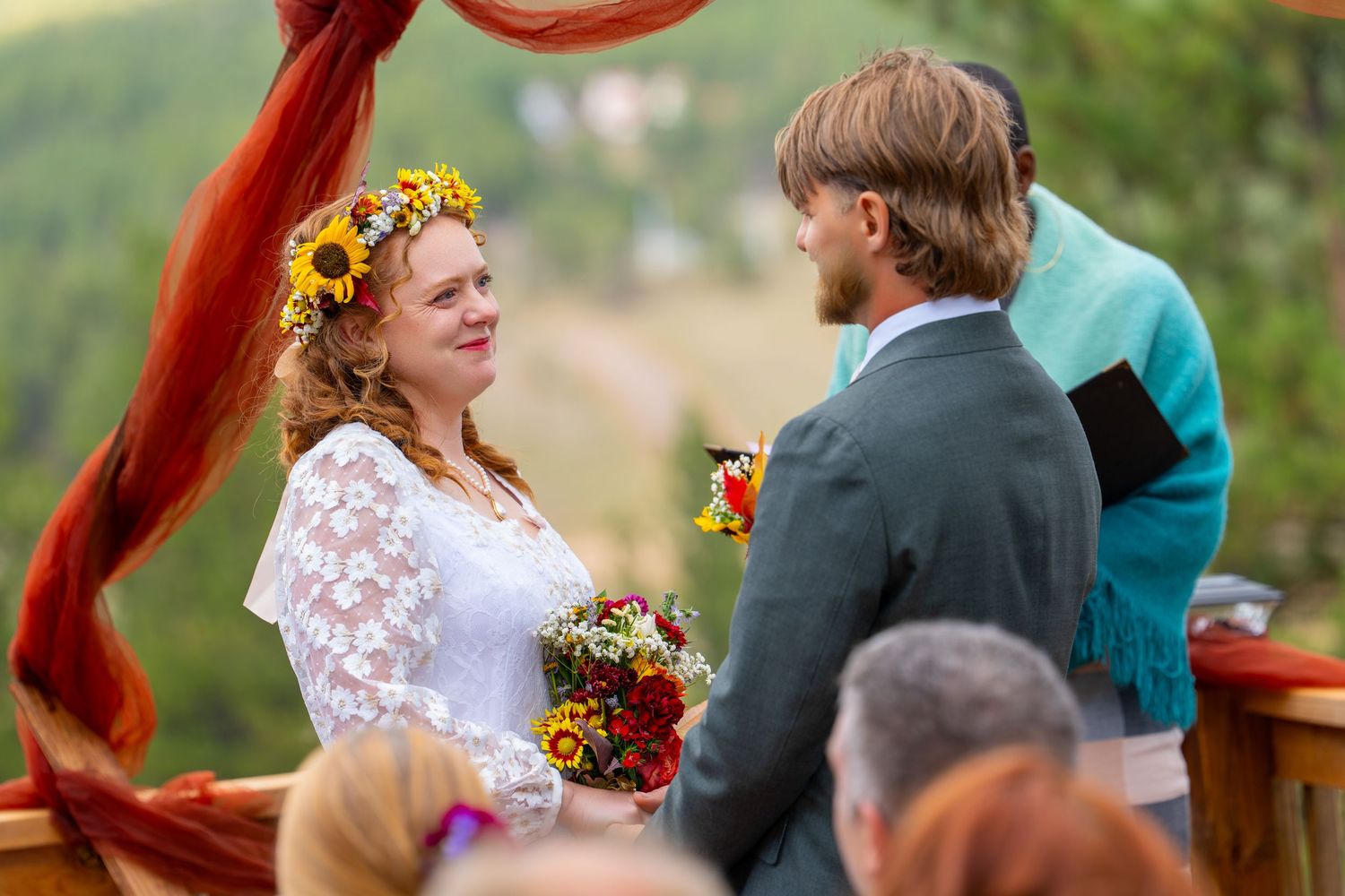 Outdoor wedding ceremony with sunflowers and rustic decor in a natural setting.
