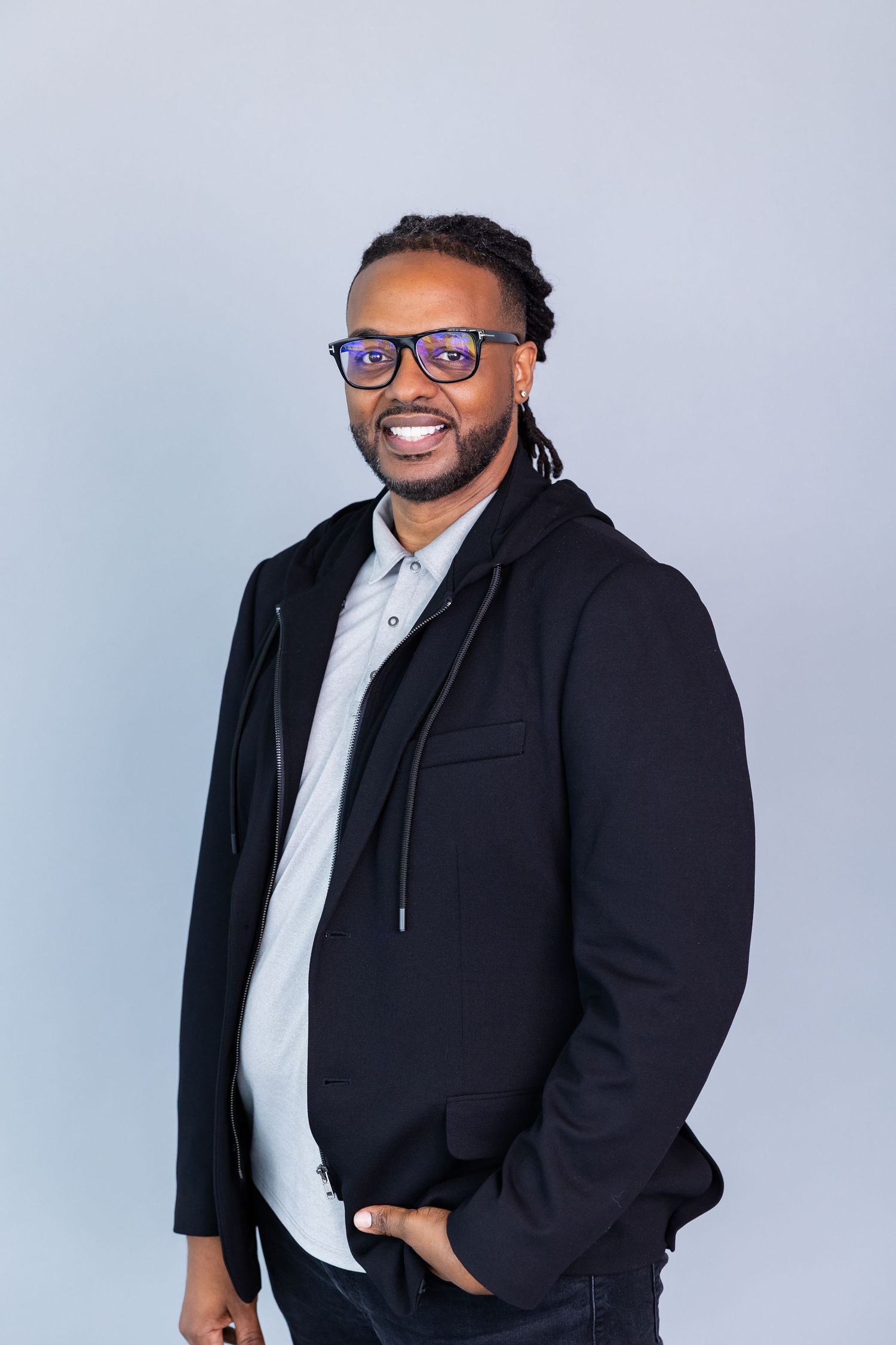 Professional portrait series showing a person in a black blazer and white shirt against a light gray background.