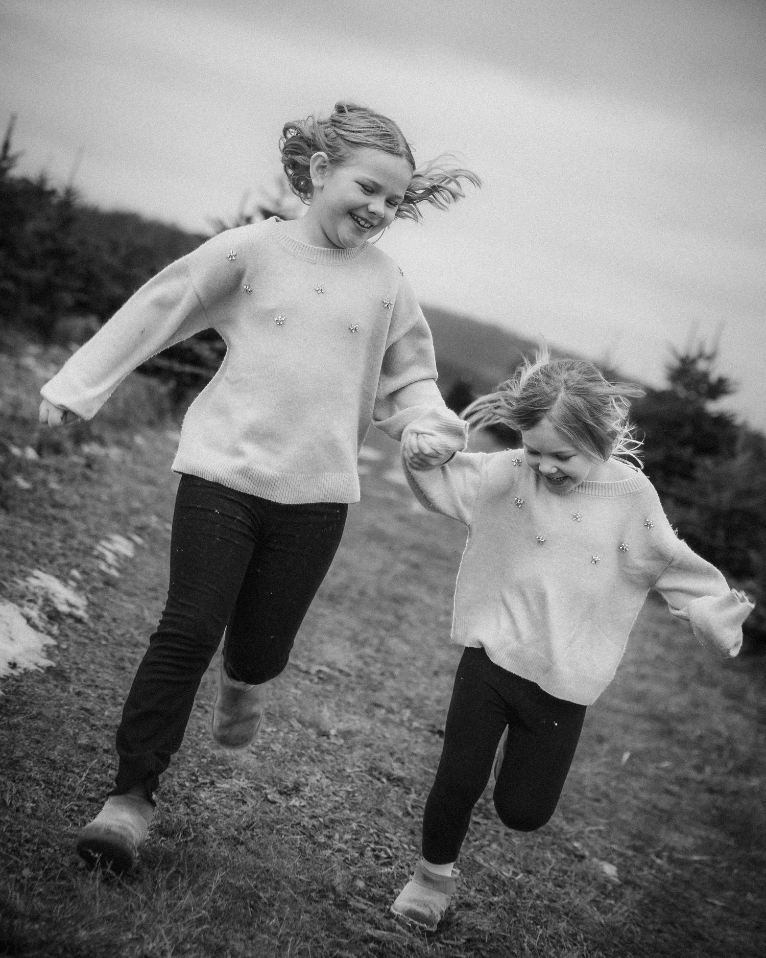 Black and white motion blur photograph showing playful movement and running on an outdoor field.