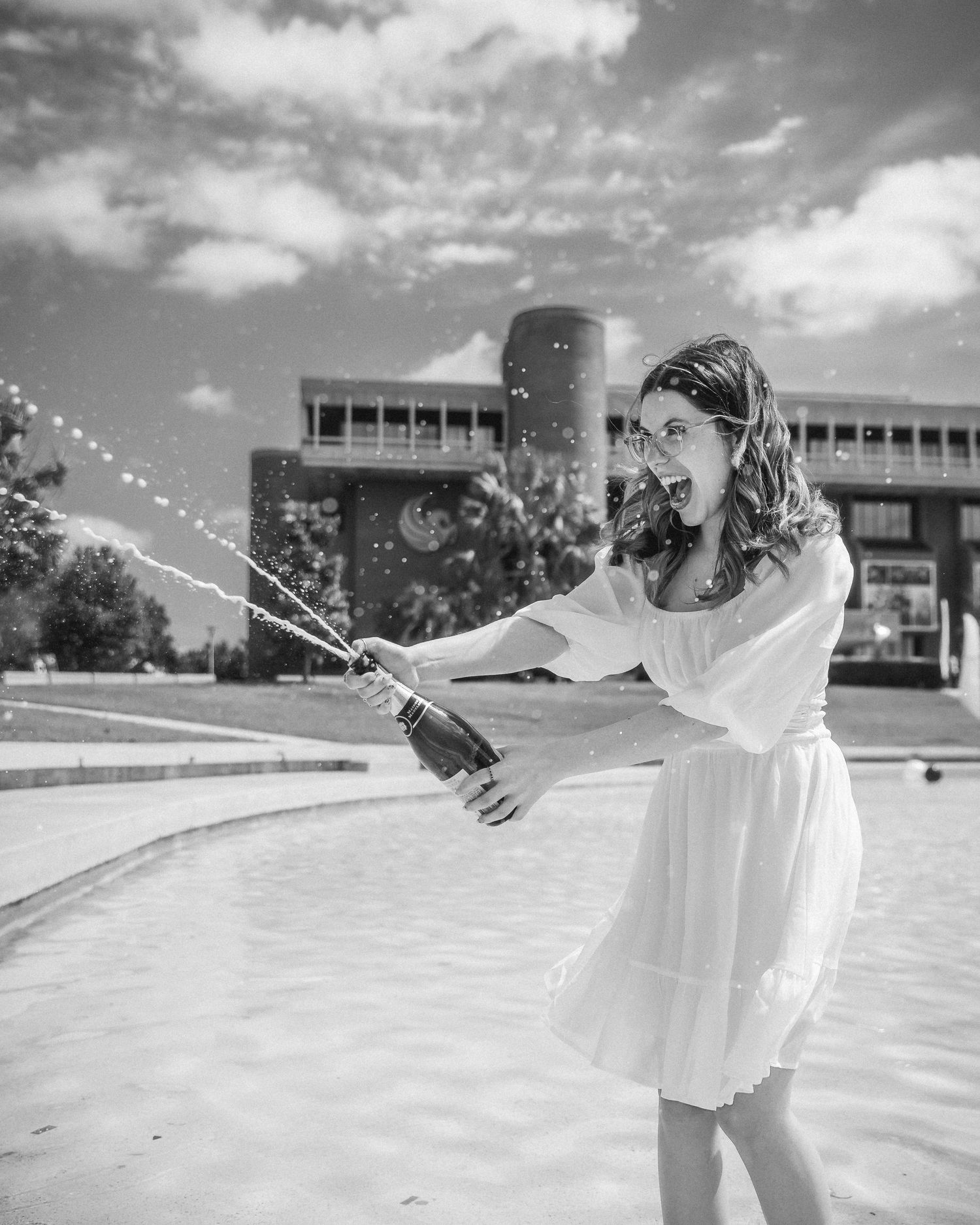 A black and white photo sequence shows someone in white spinning and dancing gracefully across a rooftop space.