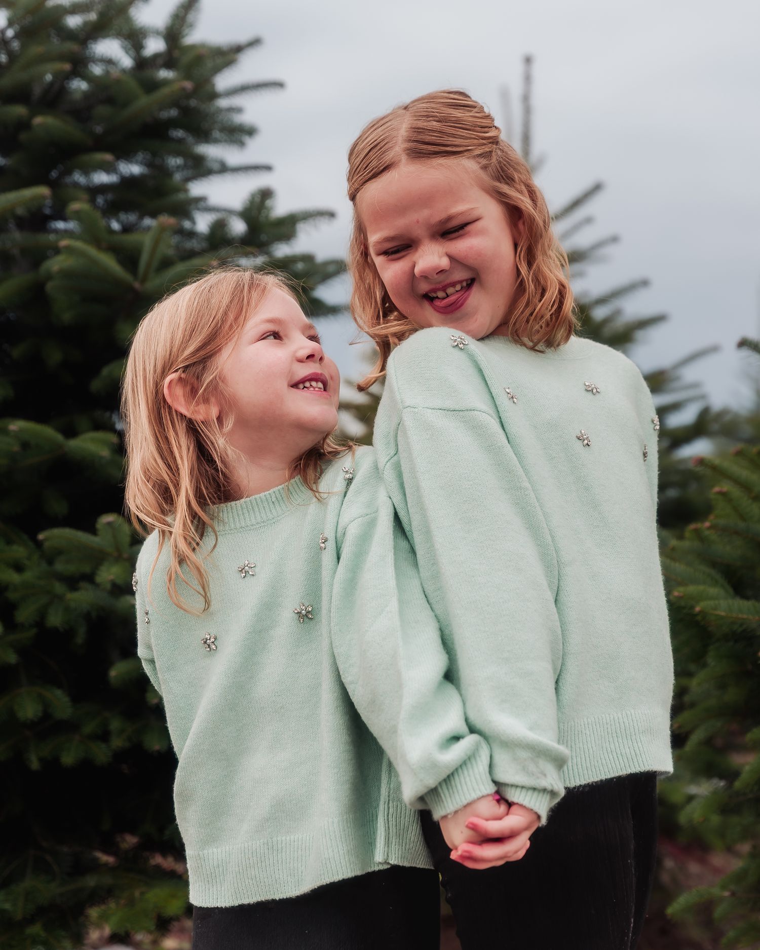 A series of candid photos showing two people in matching mint green sweaters sharing joyful moments together outdoors.