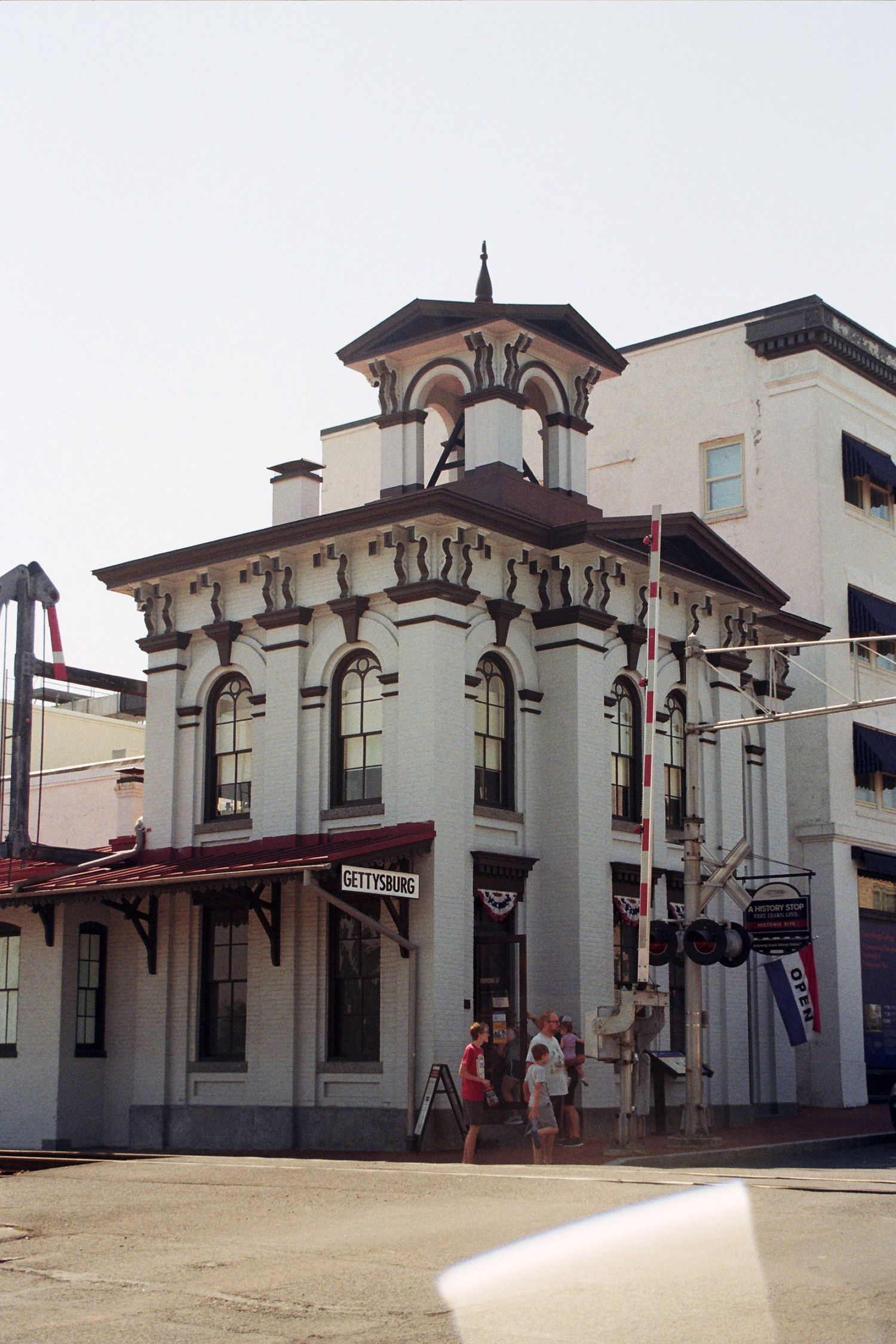 Historic white train station building with ornate architectural details and multiple arched windows and columns.
