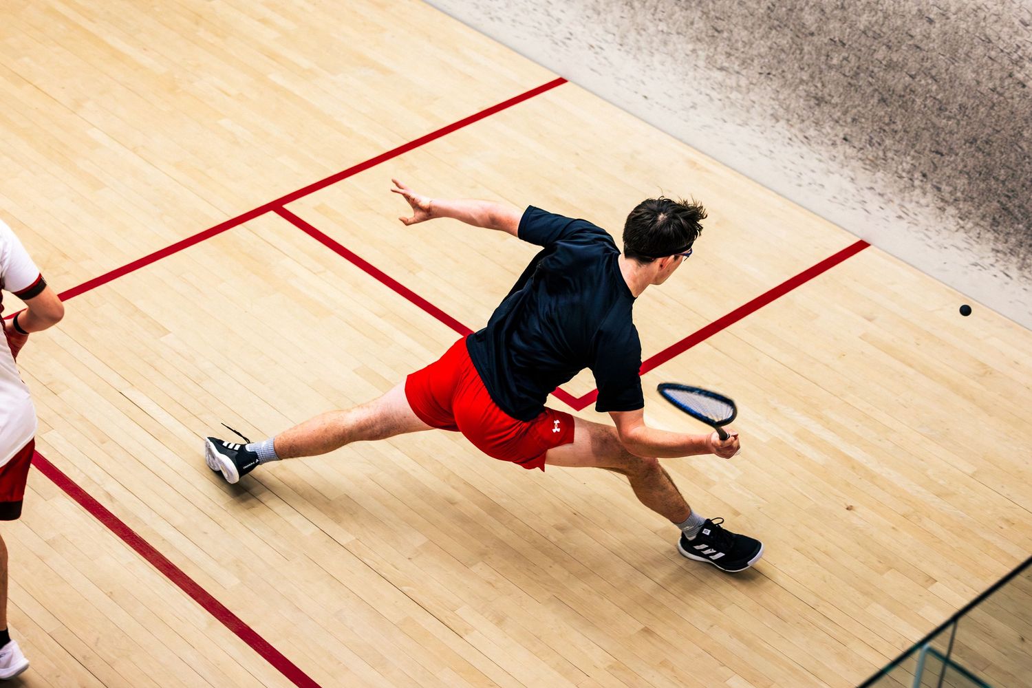 A sequence of squash players in action on the court showing various lunging and hitting positions during gameplay.