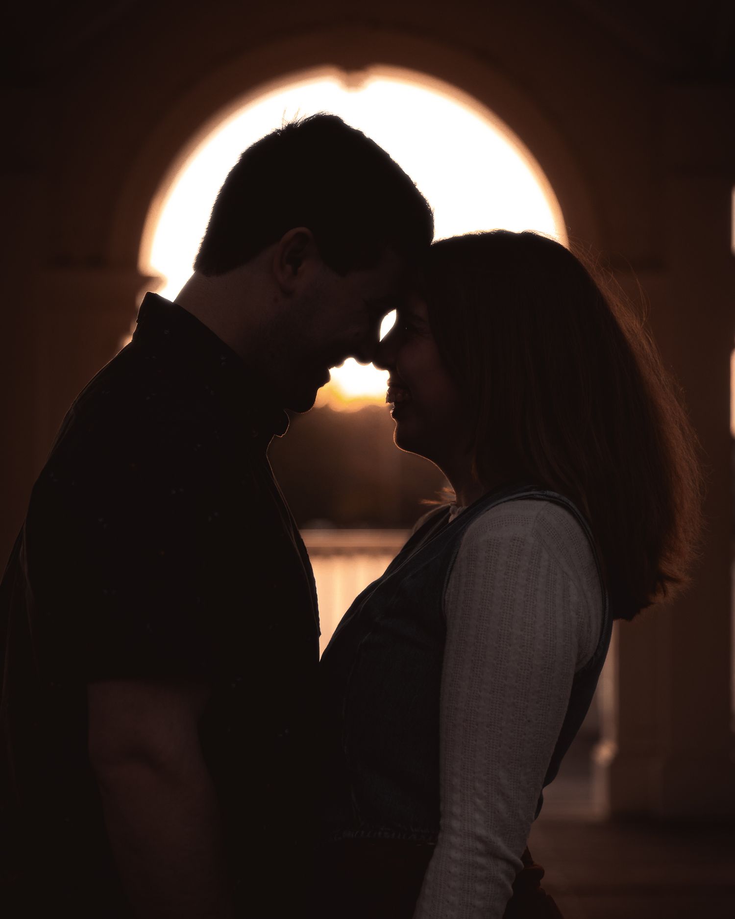 Silhouetted figures in romantic poses against a dark background with glowing light creating a dramatic mood.