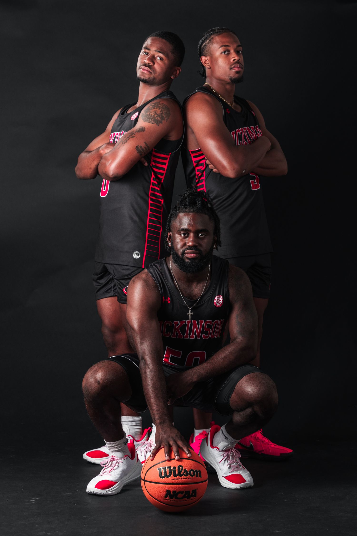 Basketball player poses in dramatic black and white studio portraits with ball and red accents.