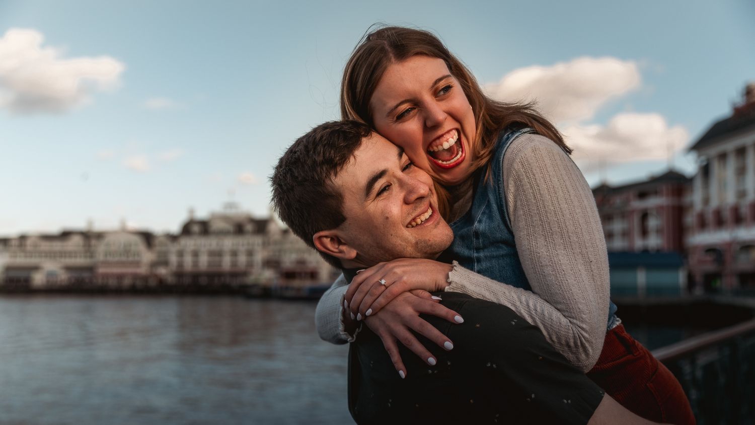 A couple embraces and laughs together in a series of candid romantic moments by the waterfront.