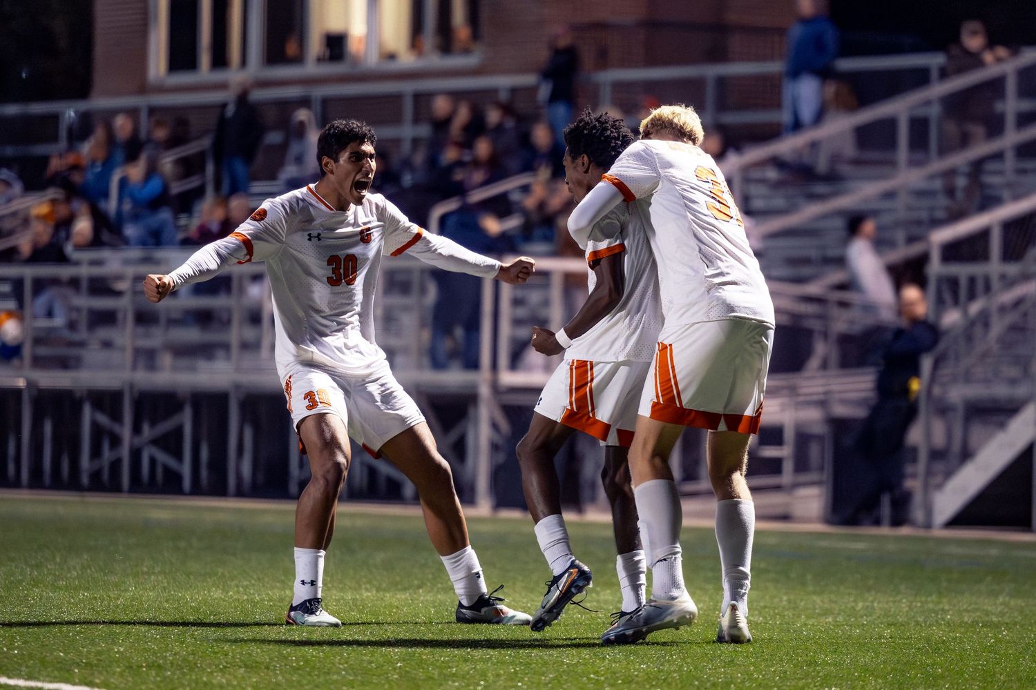 Soccer players battle for possession of the ball during an intense match at a stadium.